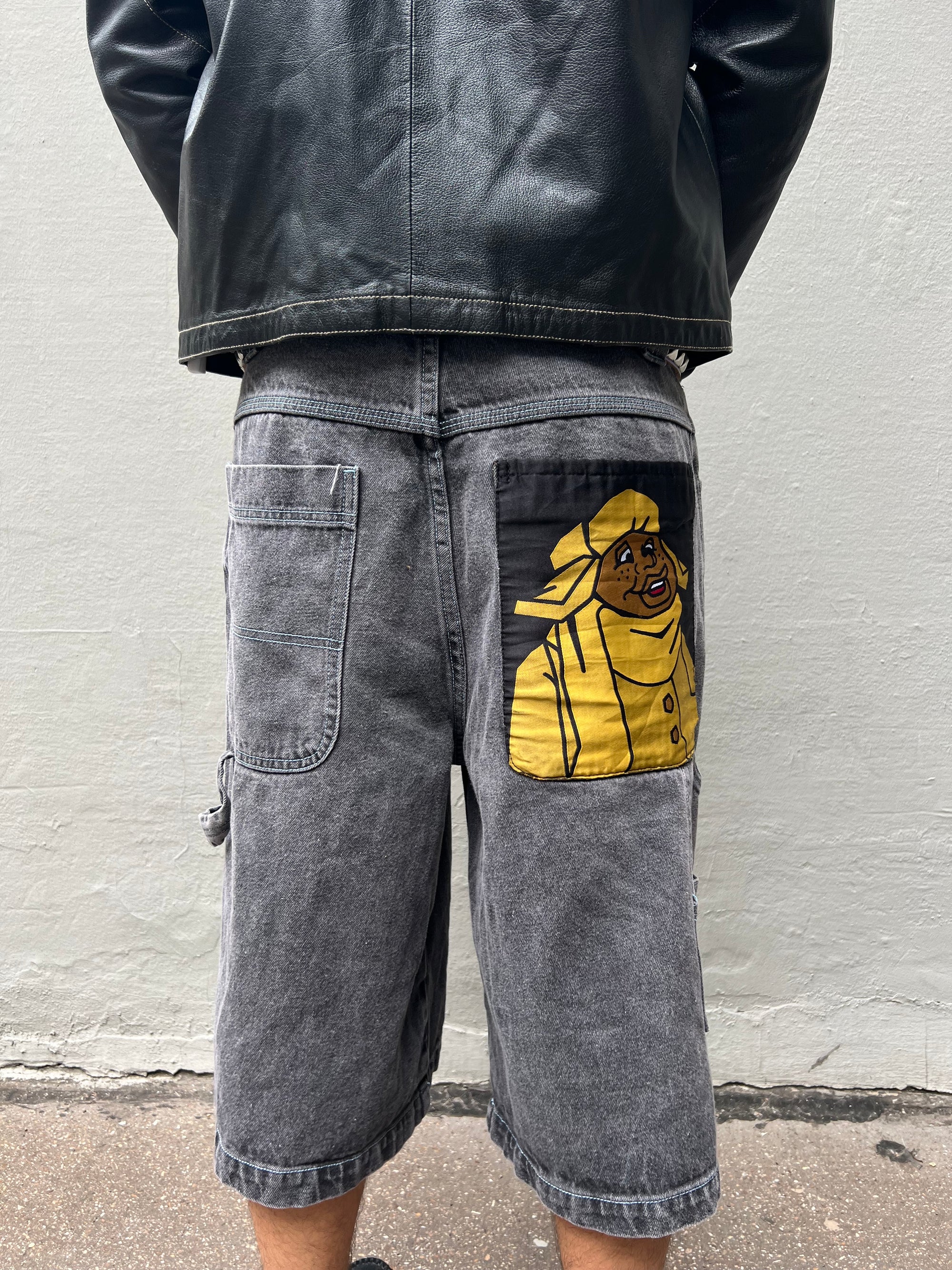 Tragebild von grauen baggy Fubu Shorts mit gelbem Backprint von hinten