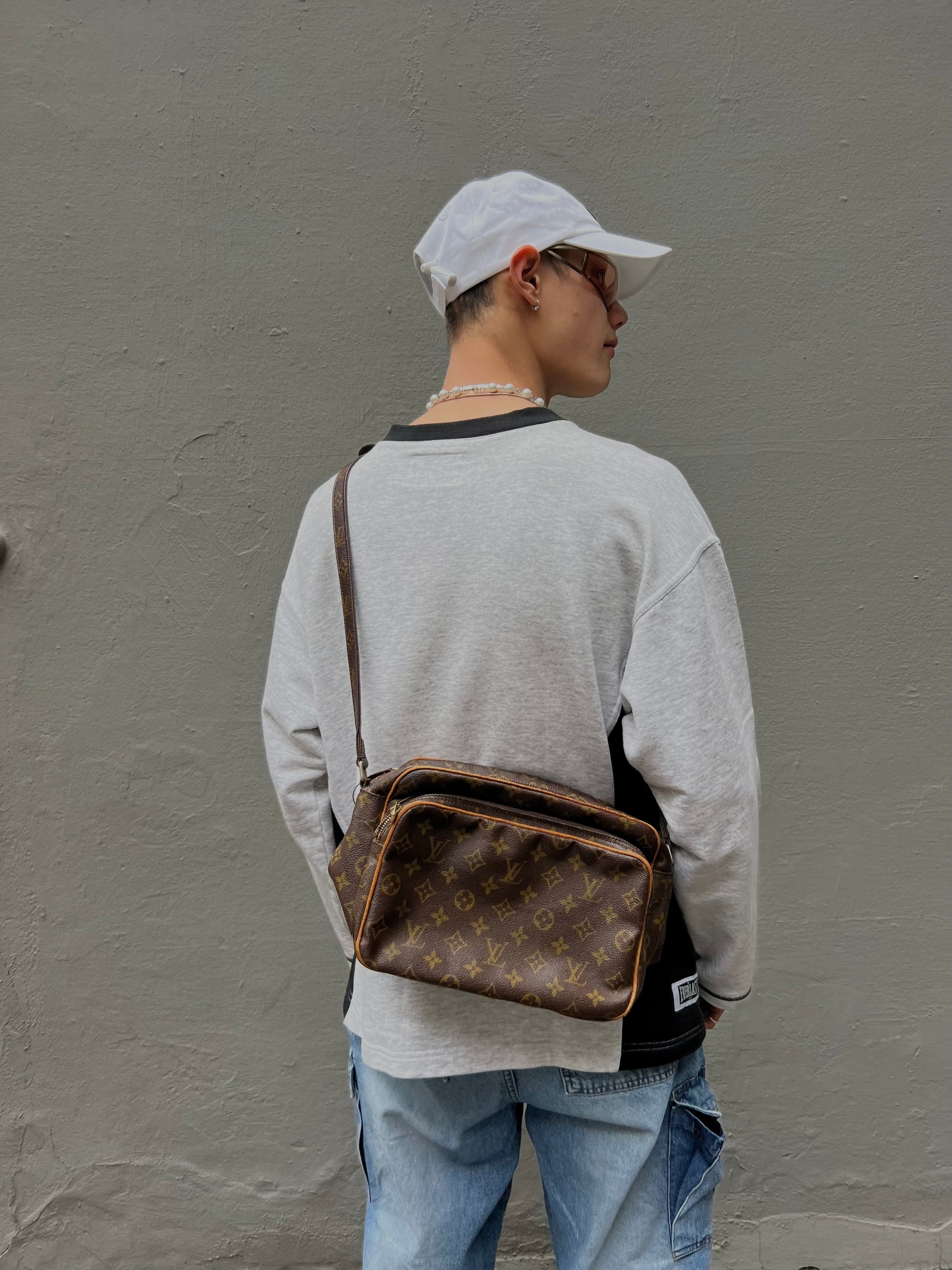 Tragefoto von luis Vuitton Tasche vor grauer Wand 