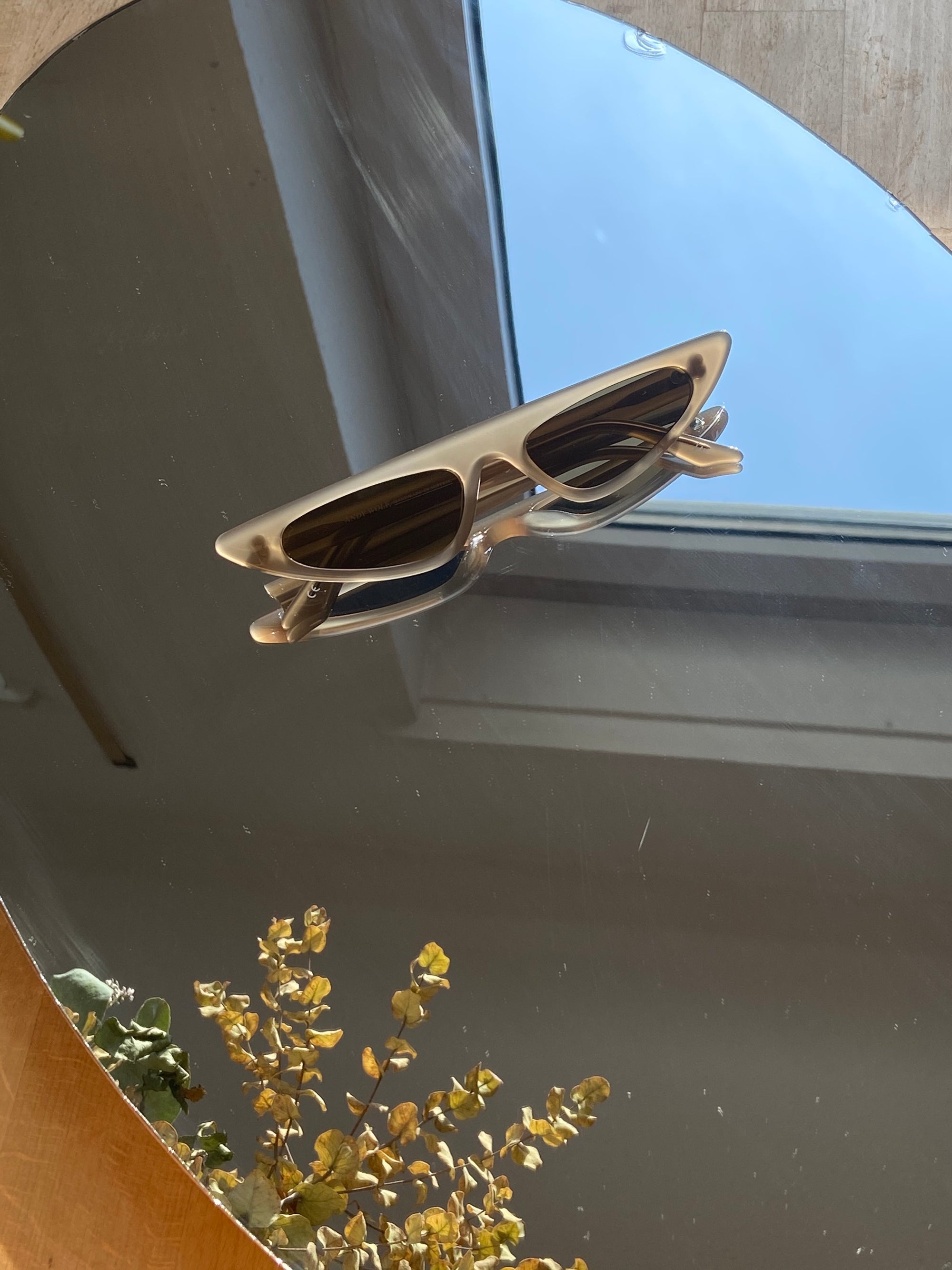 Produktbild der Andy Wole Sunglasses Florence ash von oben vor einem Spiegelhintergrund.