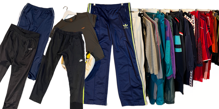 Zu sehen ist eine diverse Auswahl an Track pants. Die Farben Variieren von schwarz über blau bis zu weiß.