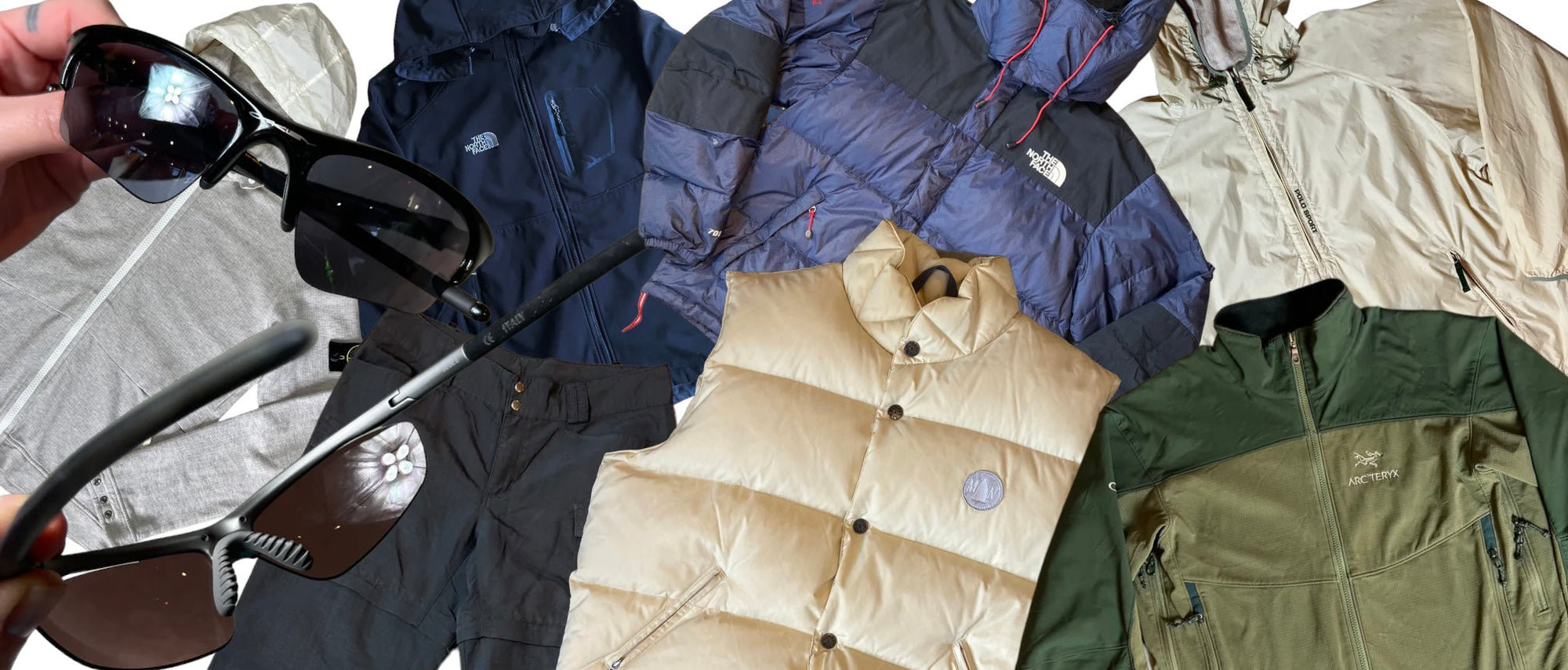 Zu sehen sind zwei Sonnenbrillen und sieben Kleidungsstücke wie eine Arcteryx Regenjacke und eine The North Face Pufferjacke.