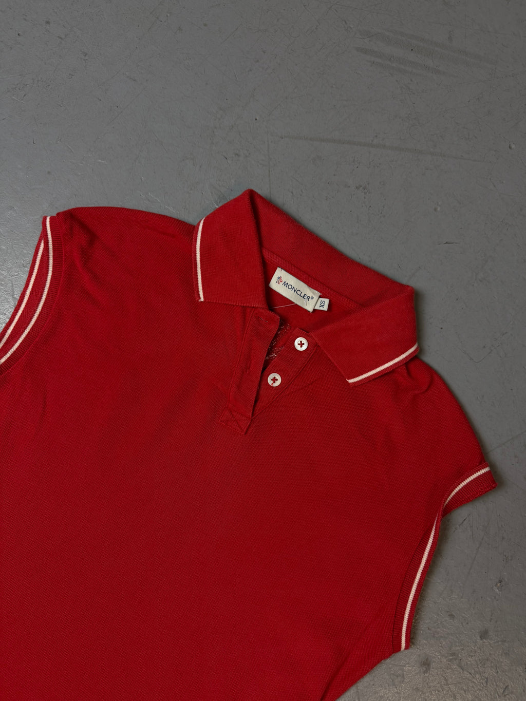 Ein rotes Moncler Polo ärmellos mit Moncler auf dem Rücken 