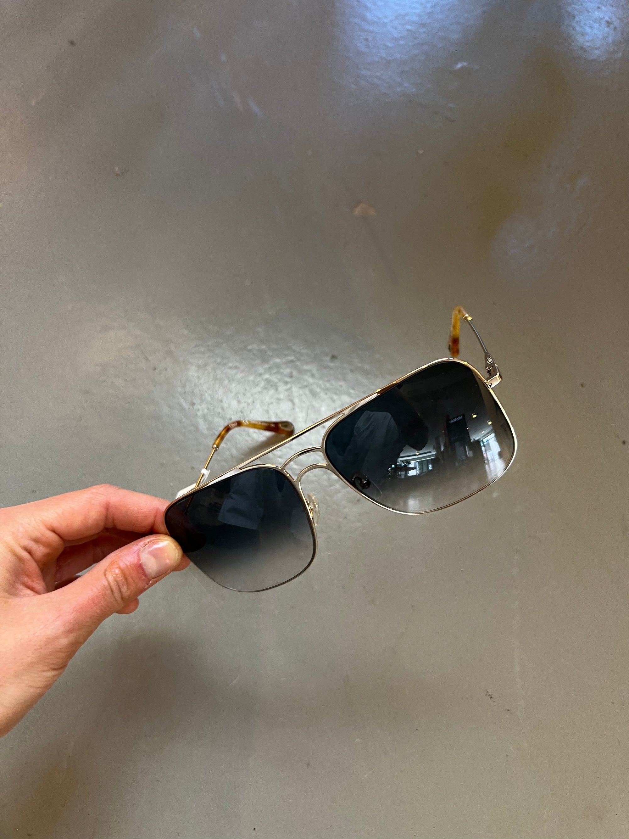 Auf dem Bild ist ein Produktbild der Chloè Sunglasses in Gold von vorne vor grauem Hintergrund zu sehen.