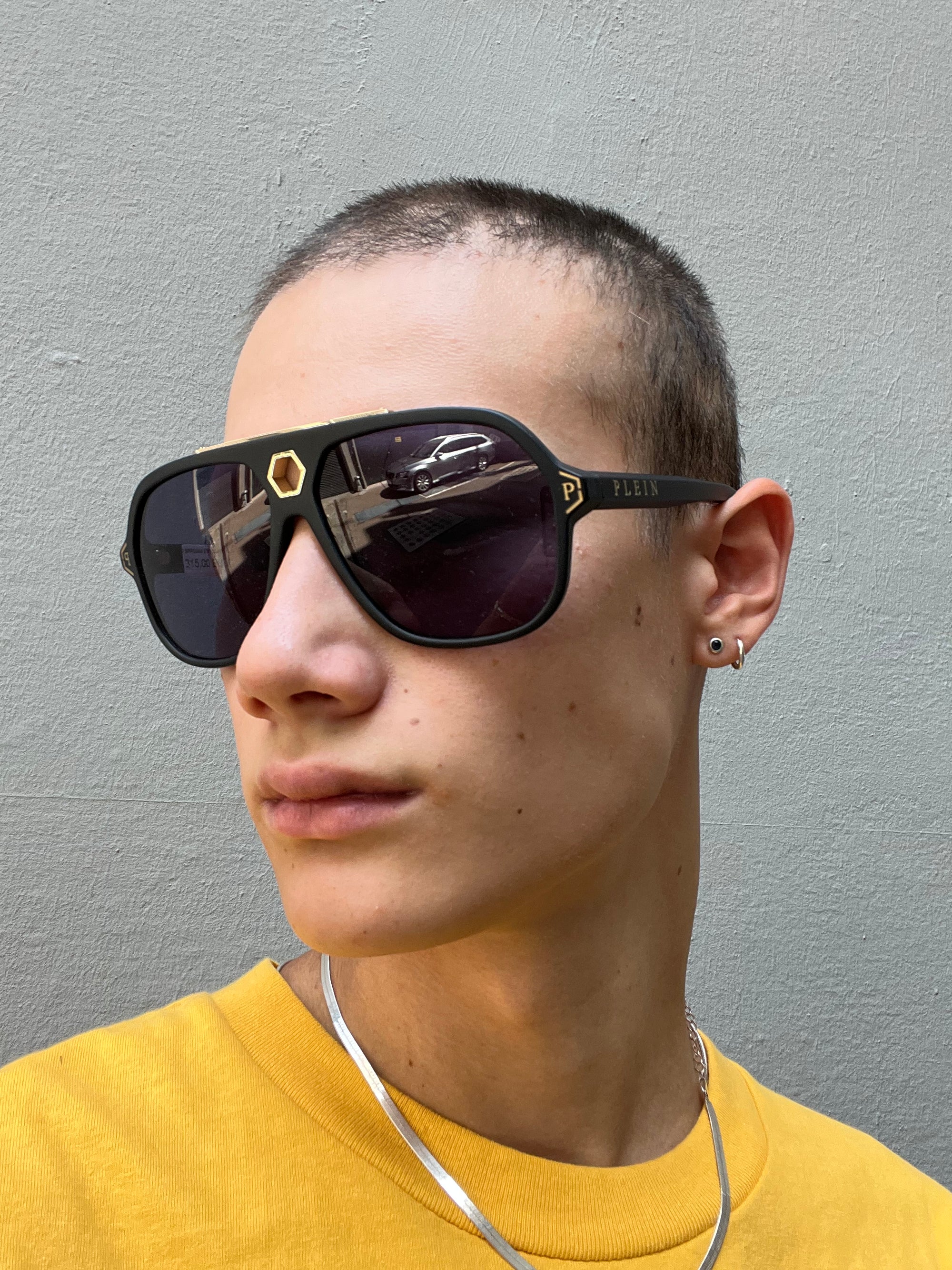 Zu sehen ist ein Tragebild von Philipp Plein Sunglasses von vorne vor einem grauen Hintergurnd.