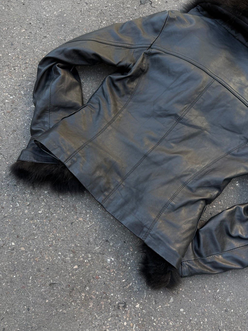 Eine schwarze Lederjacke mit Faux Fur am Kragen und an den Ärmeln