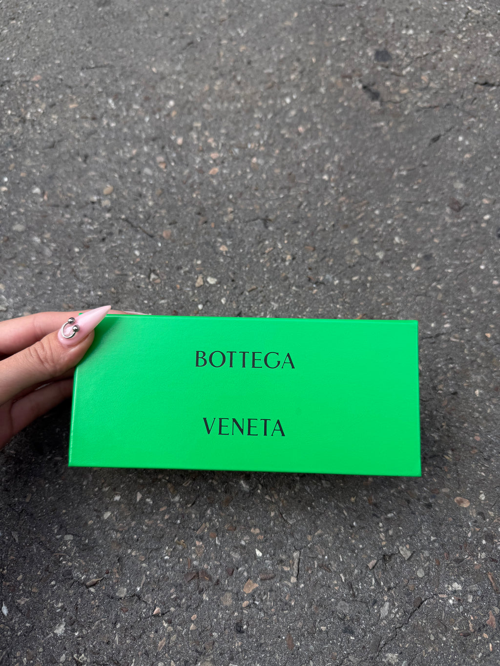 Eine beige transparente Sonnenbrille von Bottega Veneta mit Gold Details