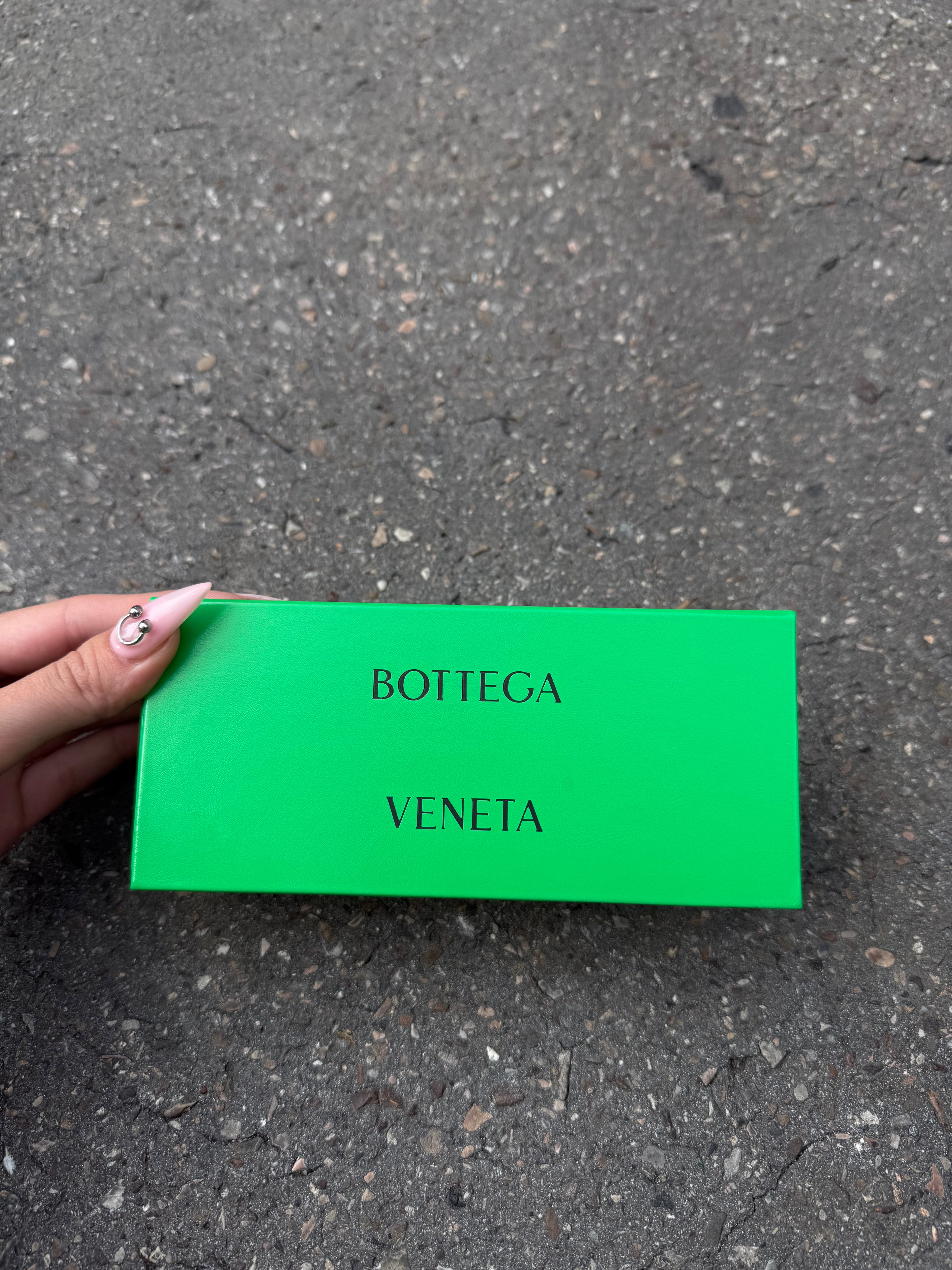 Eine beige transparente Sonnenbrille von Bottega Veneta mit Gold Details