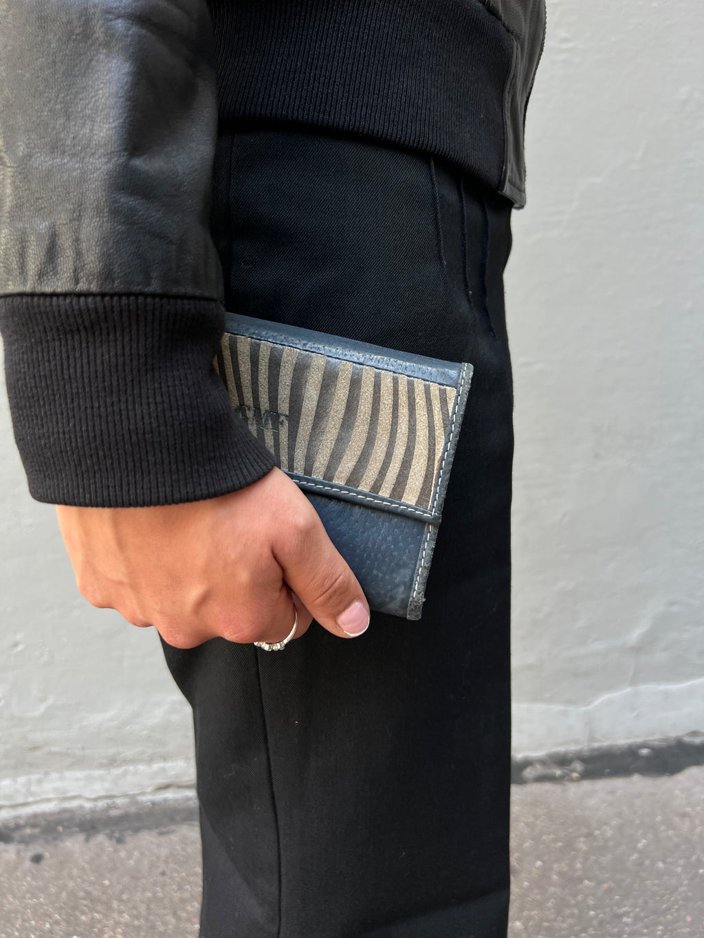 Bild von grau blauem Geldbeutel in der seitlich Hand 