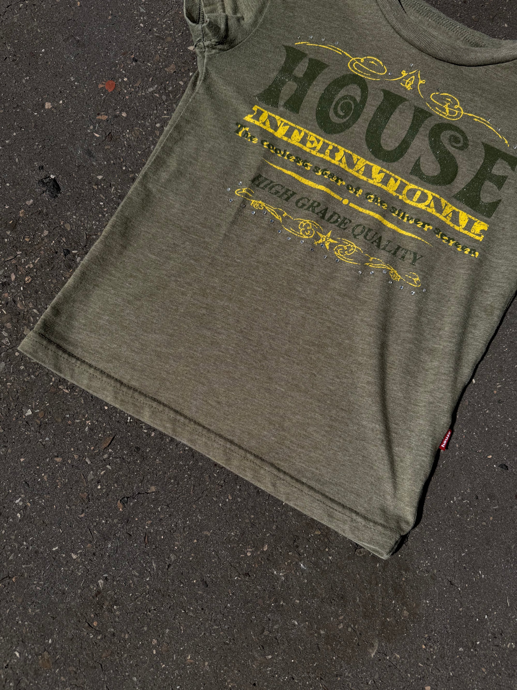Ein Khaki Baby Tee mit dunkelgrünem und gelbem Print auf der Vorderseite 