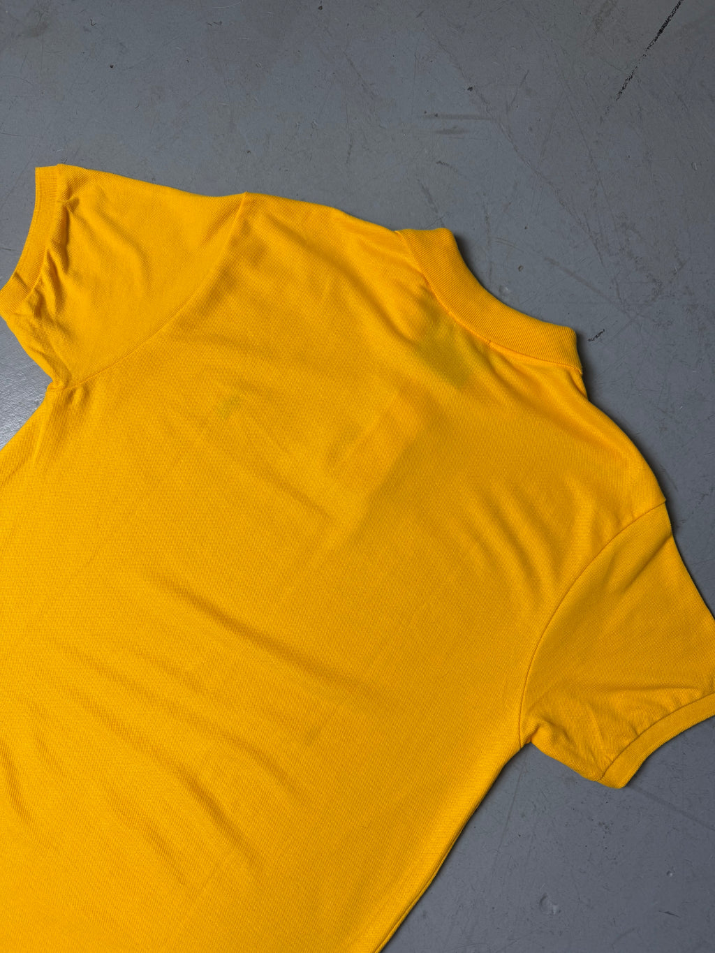 Ein gelbes Polo von Ralph Lauren mit blauem Reiter auf der Brust in L