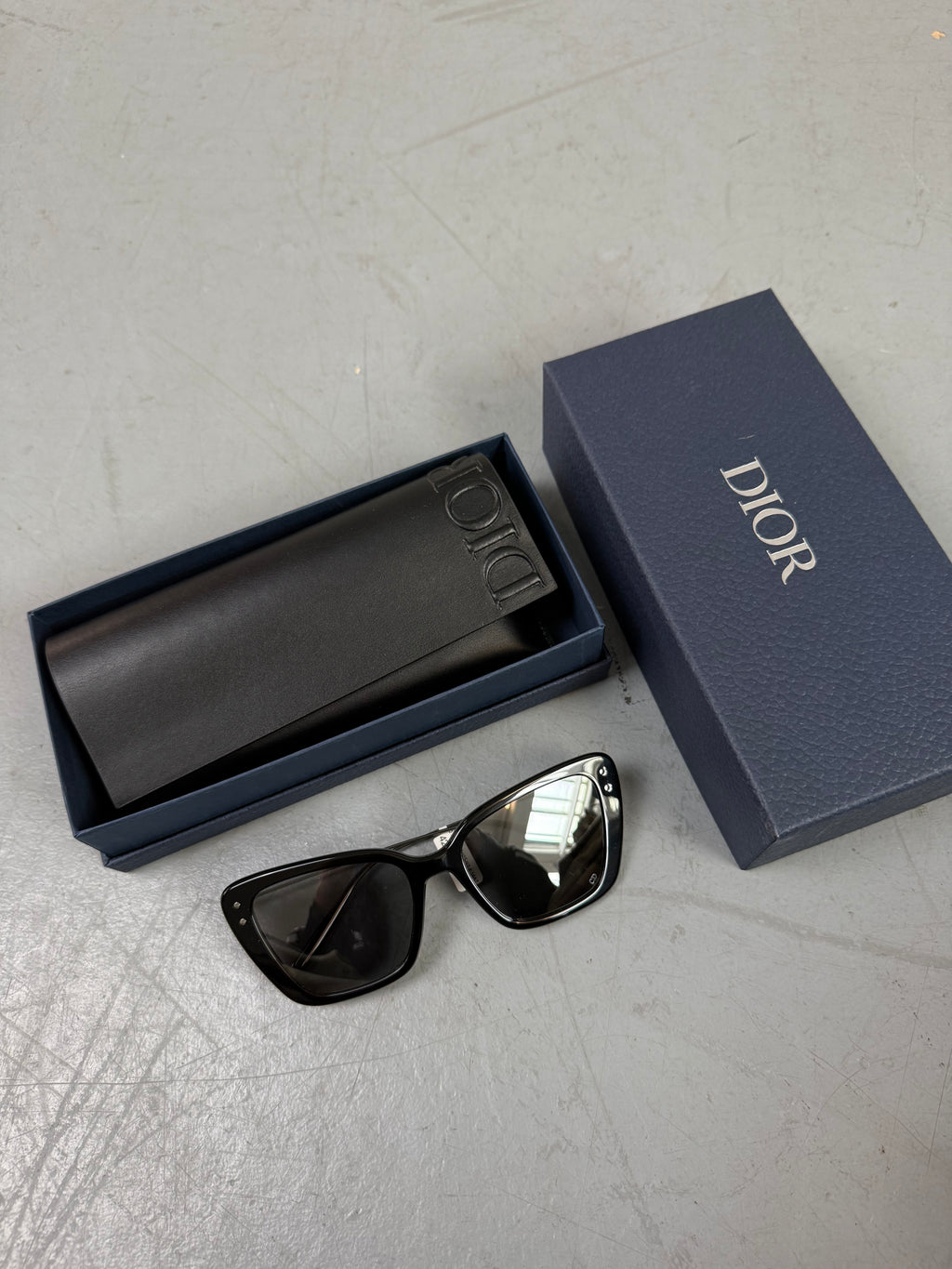 Eine schwarze Sonnenbrille von Dior mit dünnen Bügeln und die Gläser im cateye look 