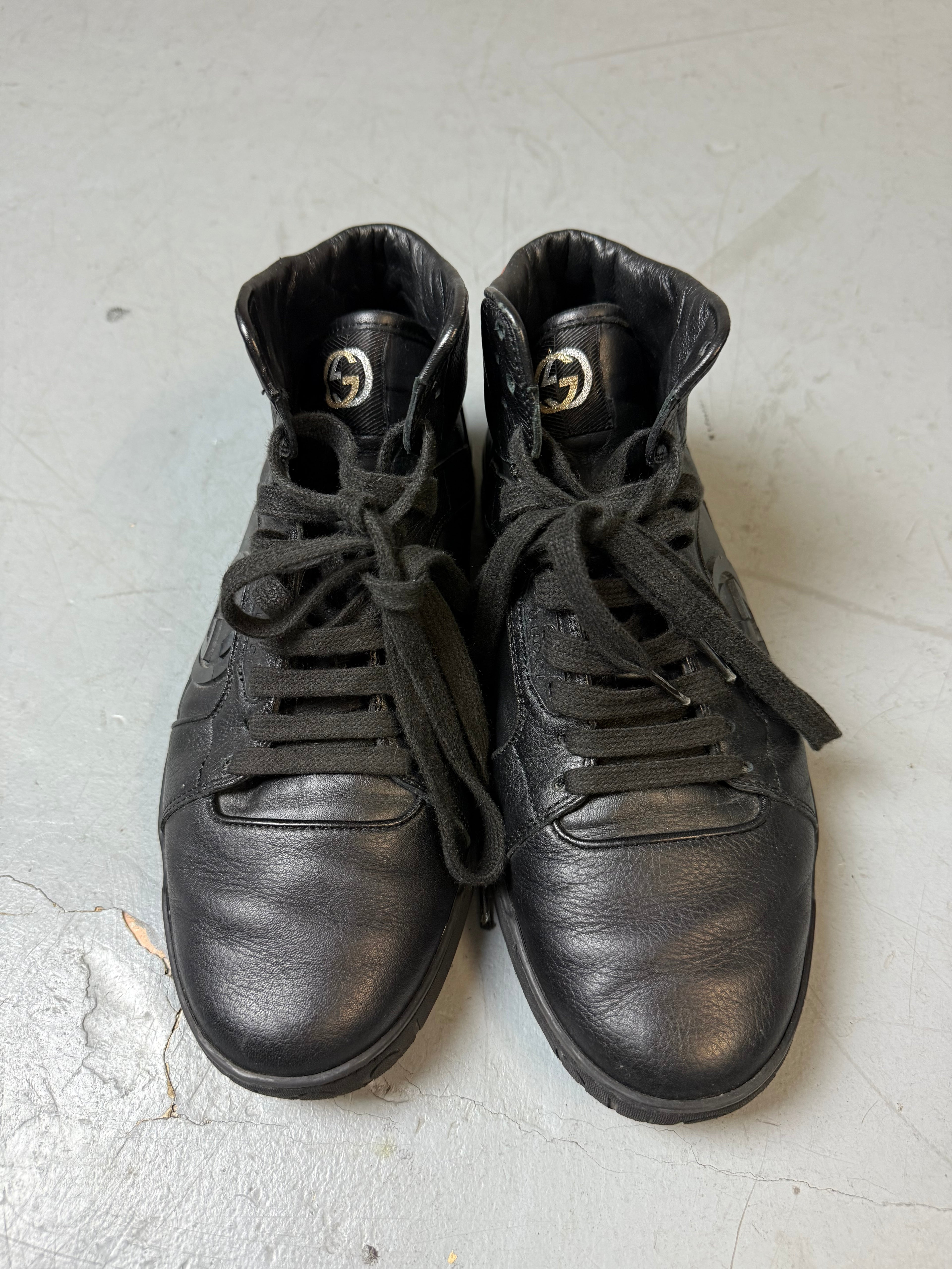 Schwarze gucci sneaker mit roten details hinten und roter sohle 