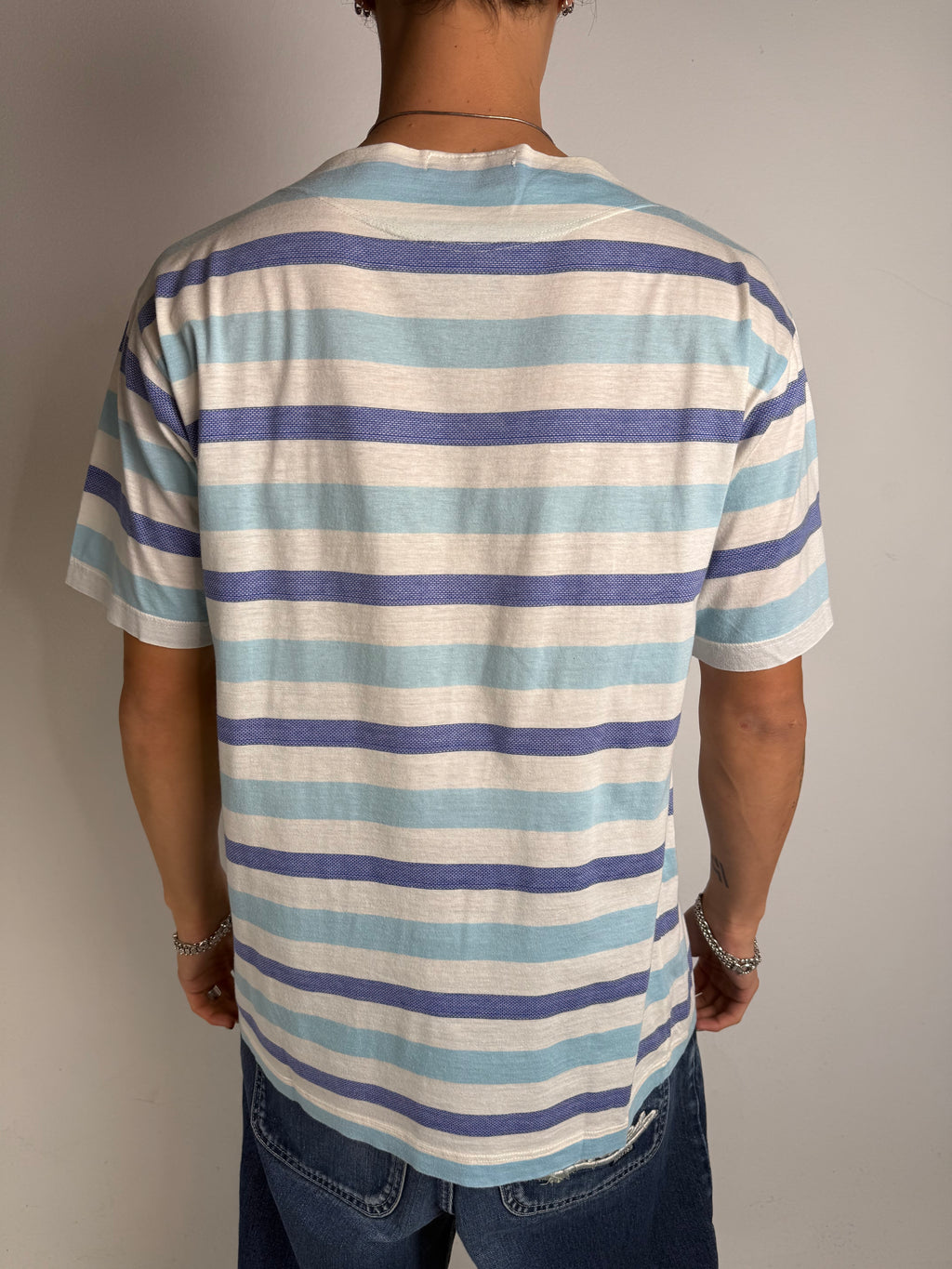 Tragebild von blau weis gestreiftem Stone Island Tshirt vor grauer Wand