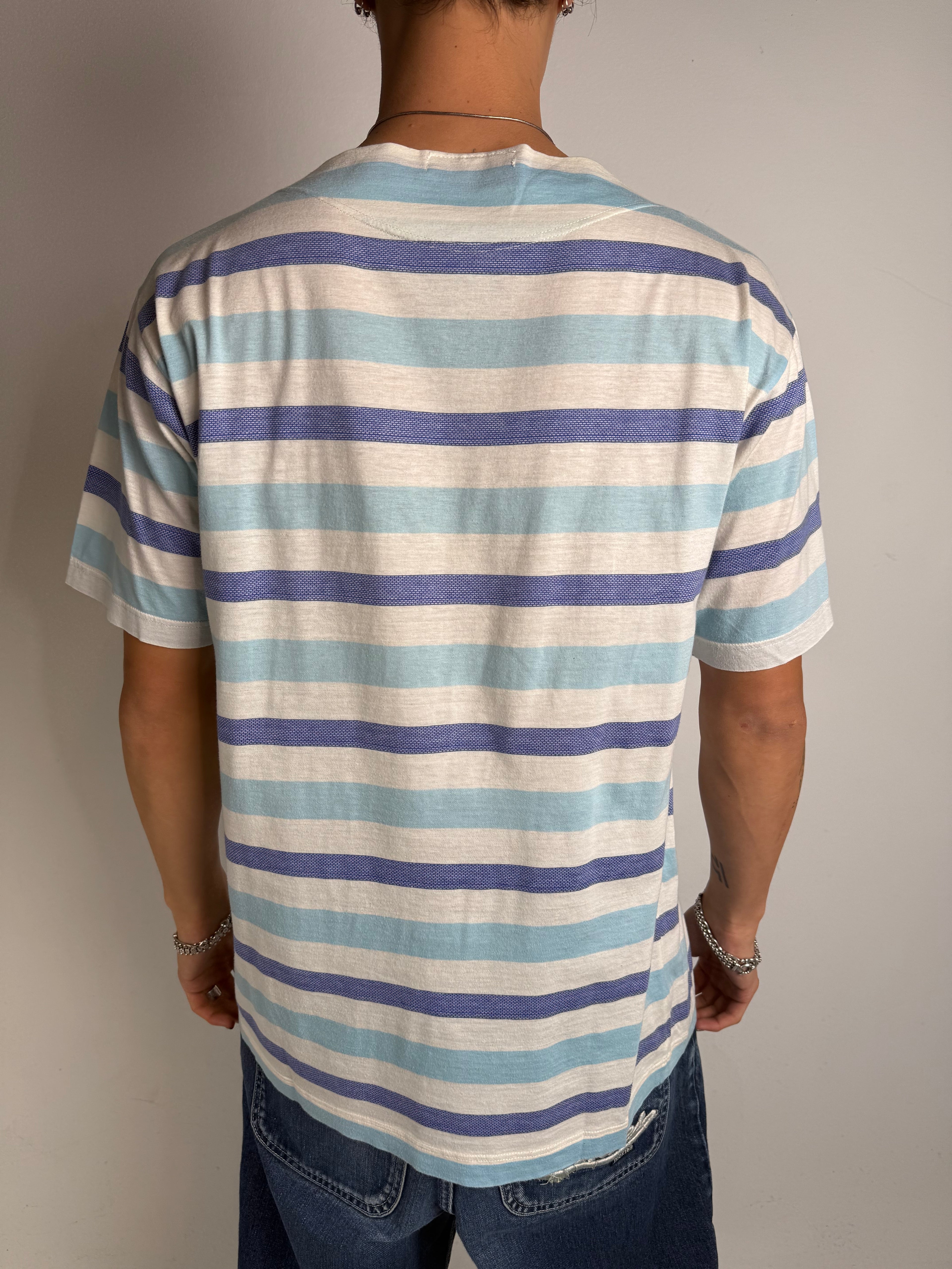 Tragebild von blau weis gestreiftem Stone Island Tshirt vor grauer Wand