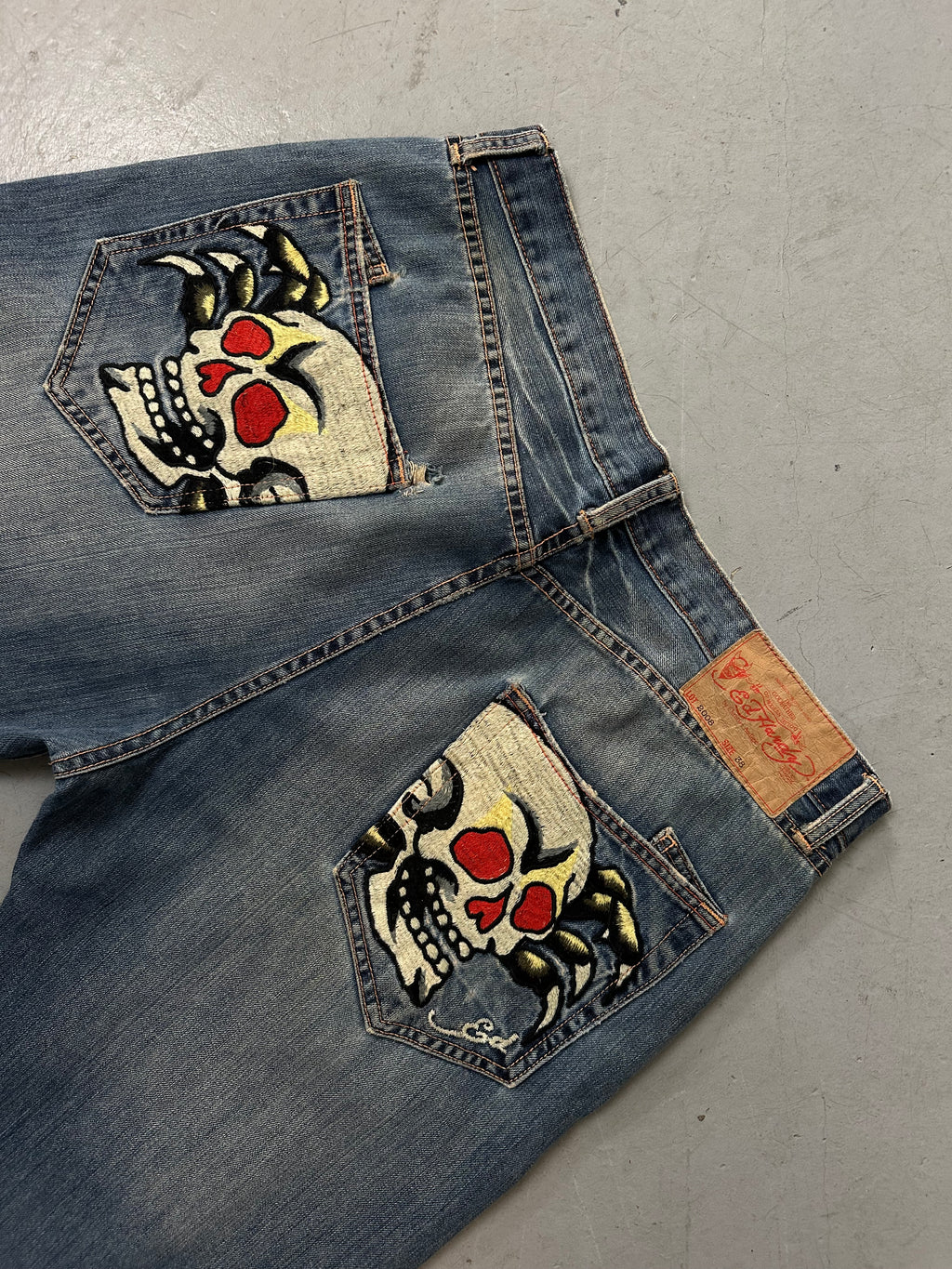 Eine baggy Ed Hardy denim mit totenkopf Print auf den backpockets