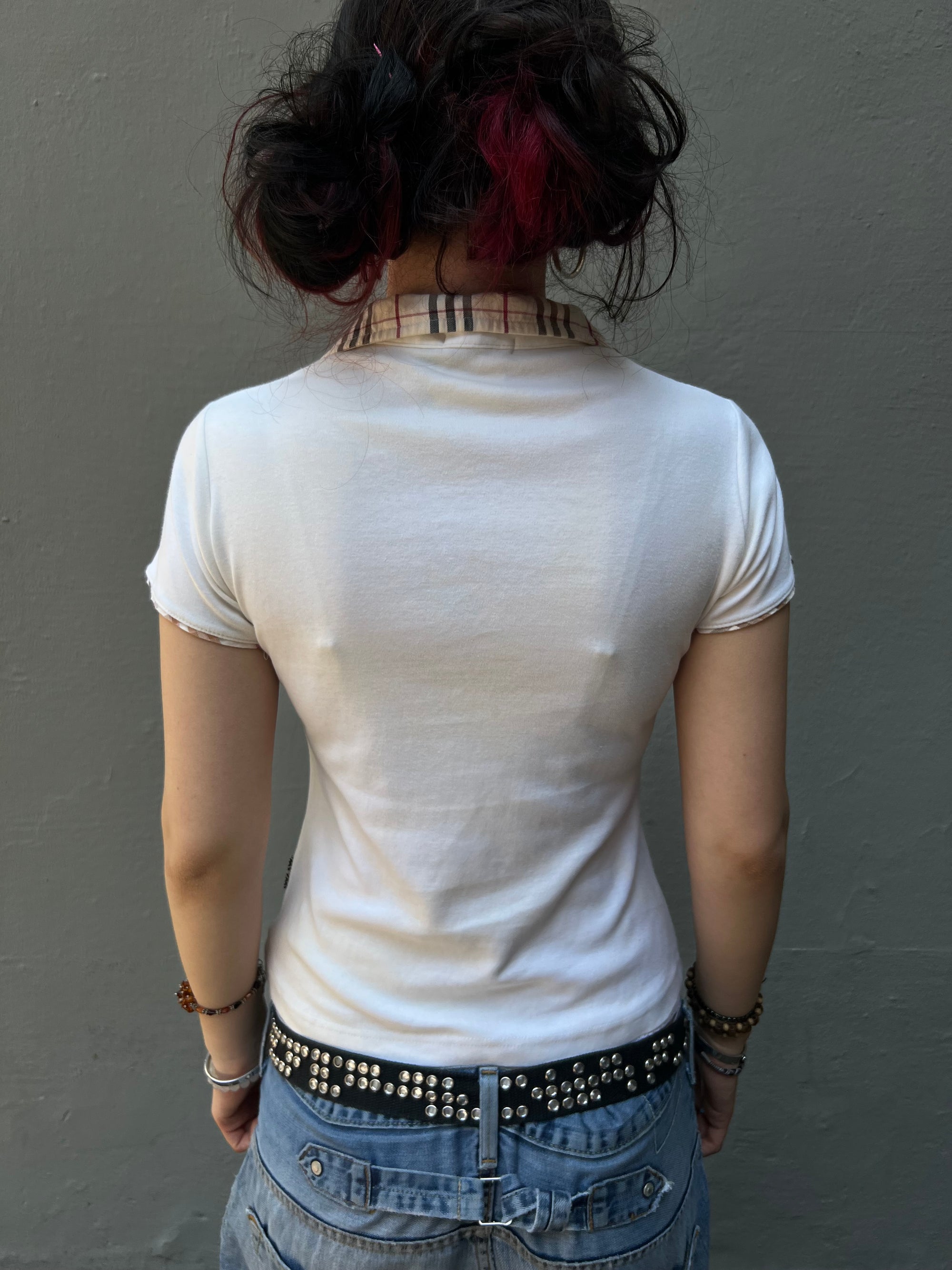 Ein beiges cropped Burberry Polo mit schwarzem Logo auf der Brust 