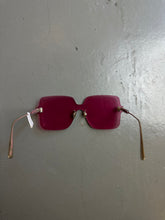 Laden Sie das Bild in den Galerie-Viewer, Detail-Produktbild von einer pinken Christian Dior Sonnenbrille ohne Rahmen vor grauem Hintergrund.