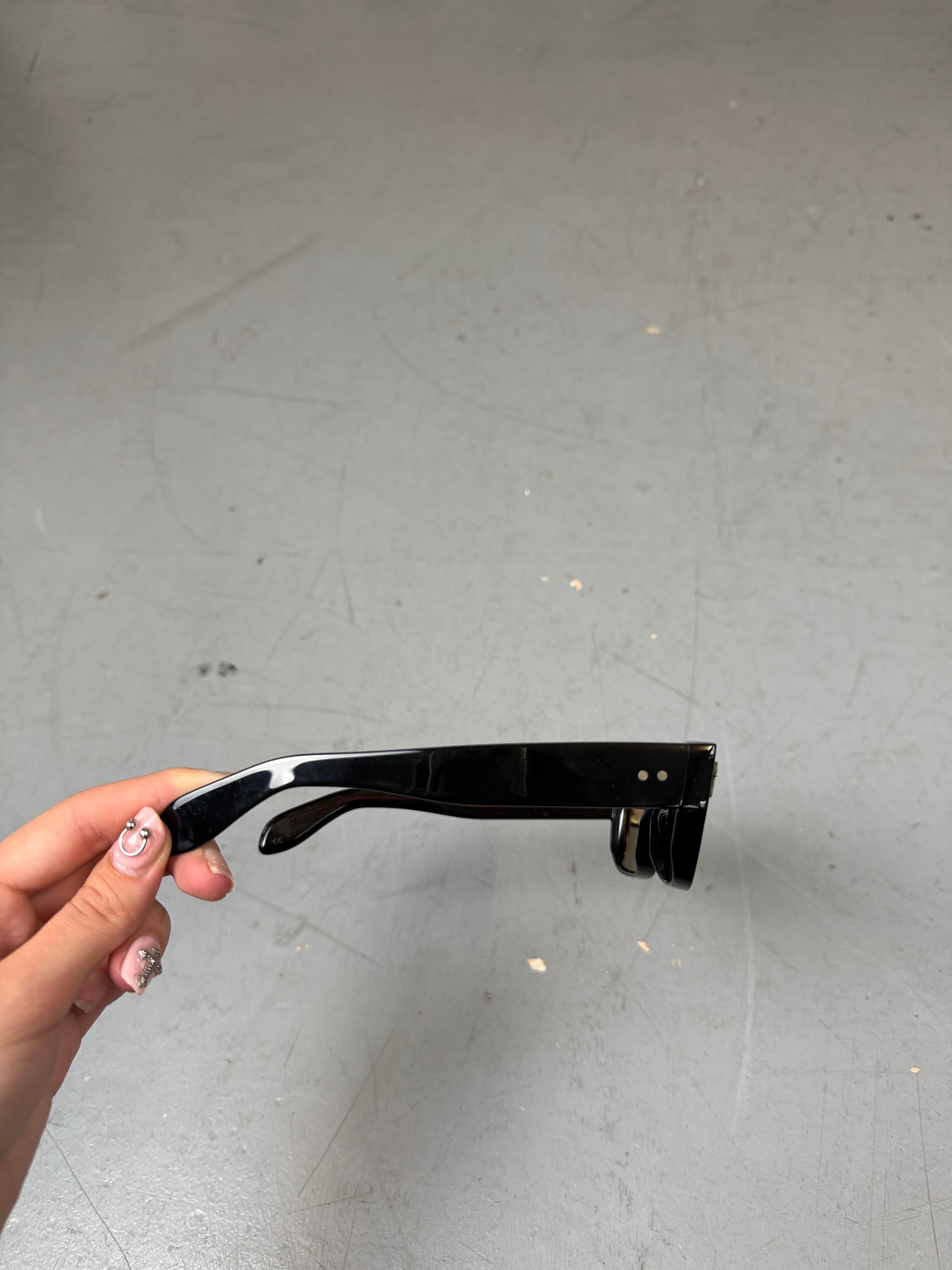 Schwarze Sonnenbrille von cutler & gross mit kleinen Dolch Details am Gestell 