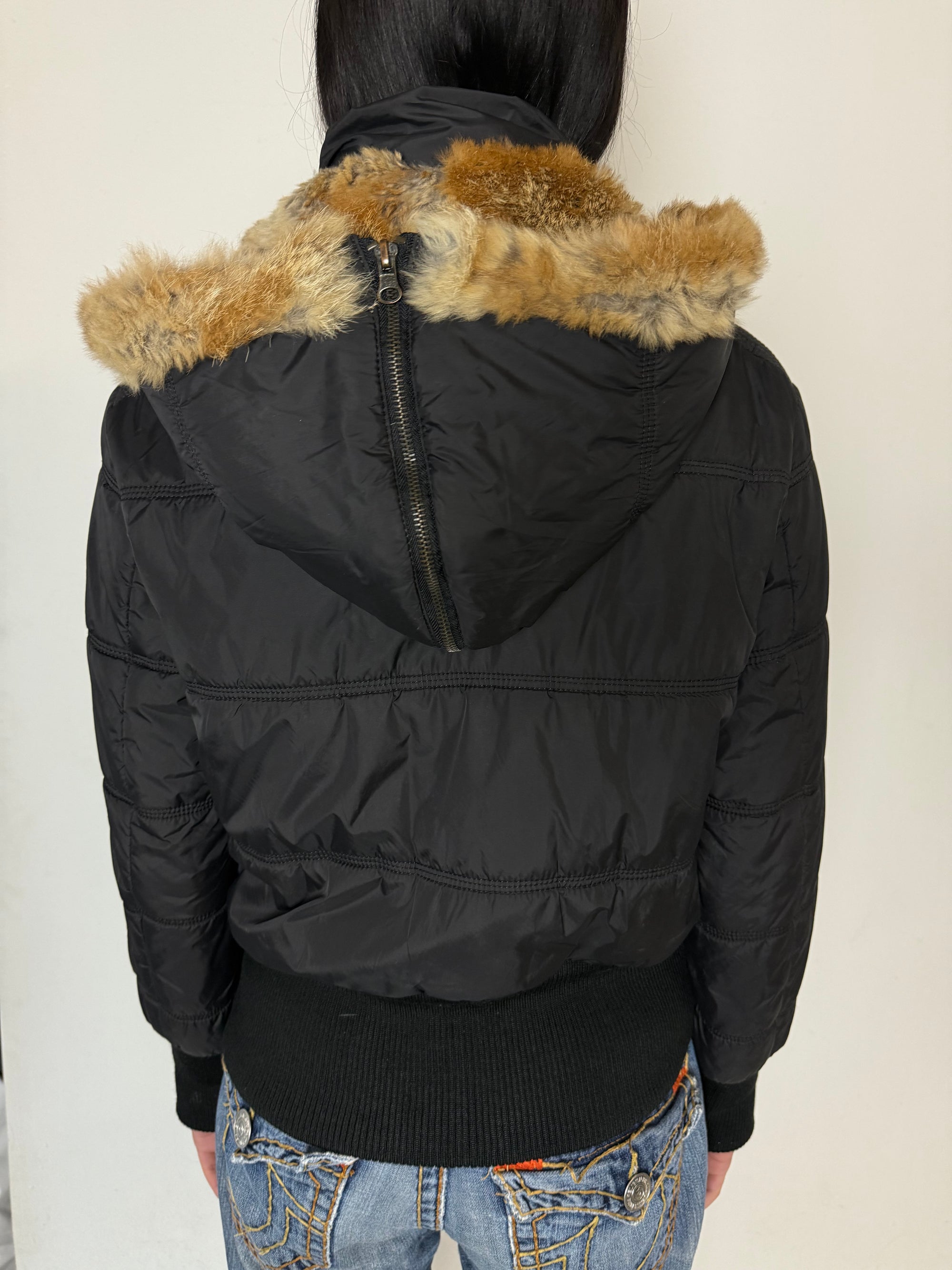 Eine schwarze cropped Puffer Jacke im Y2K Stil mit faux fur Kaputze 