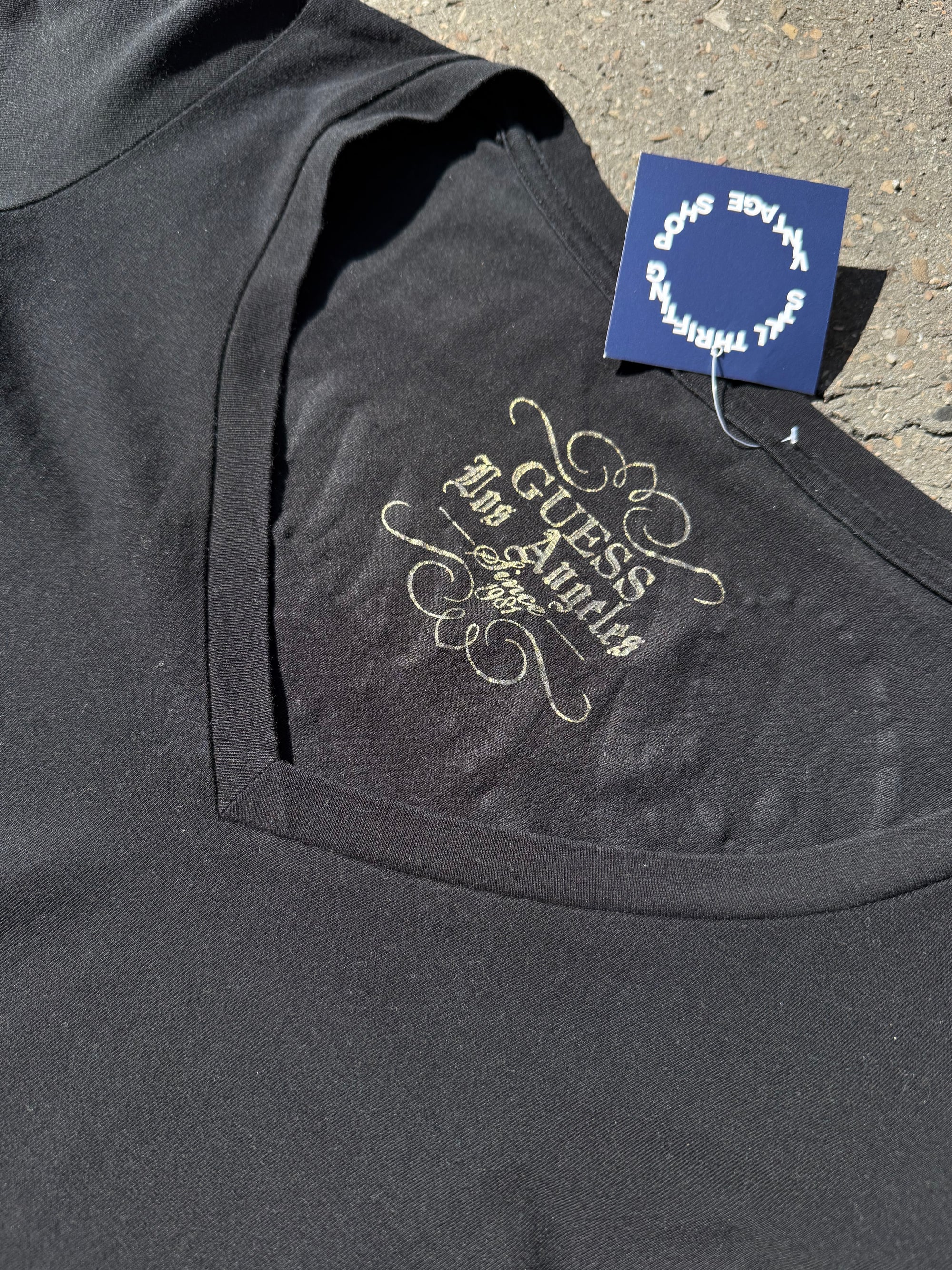 Ein schwarzes Longsleeve von Guess mit goldenem Schriftzug auf der Vorderseite und Rückseite Slim Fit