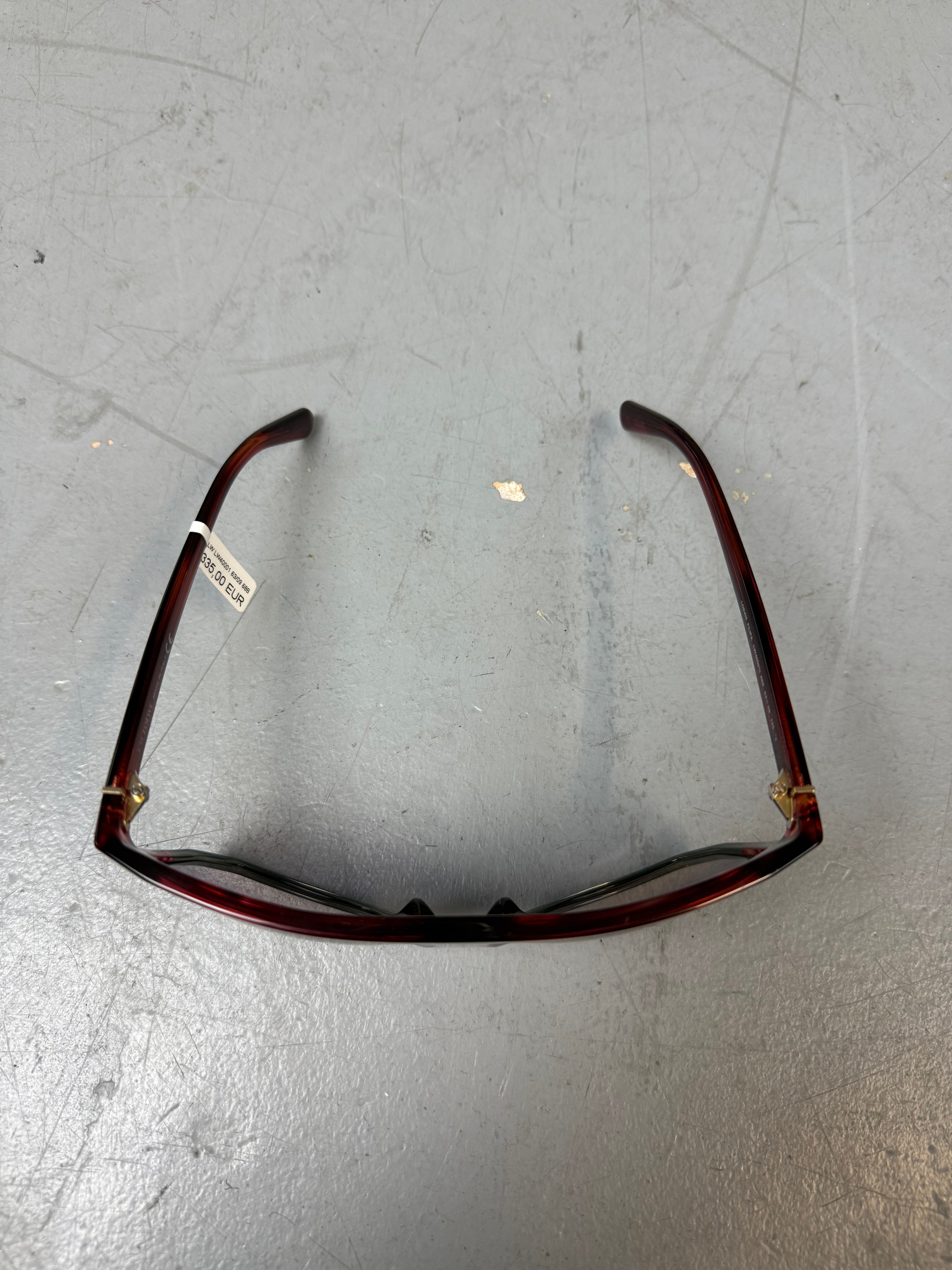 Eine Loewe Sonnenbrille mit großen dunklen Gläsern und rotem Gestell 