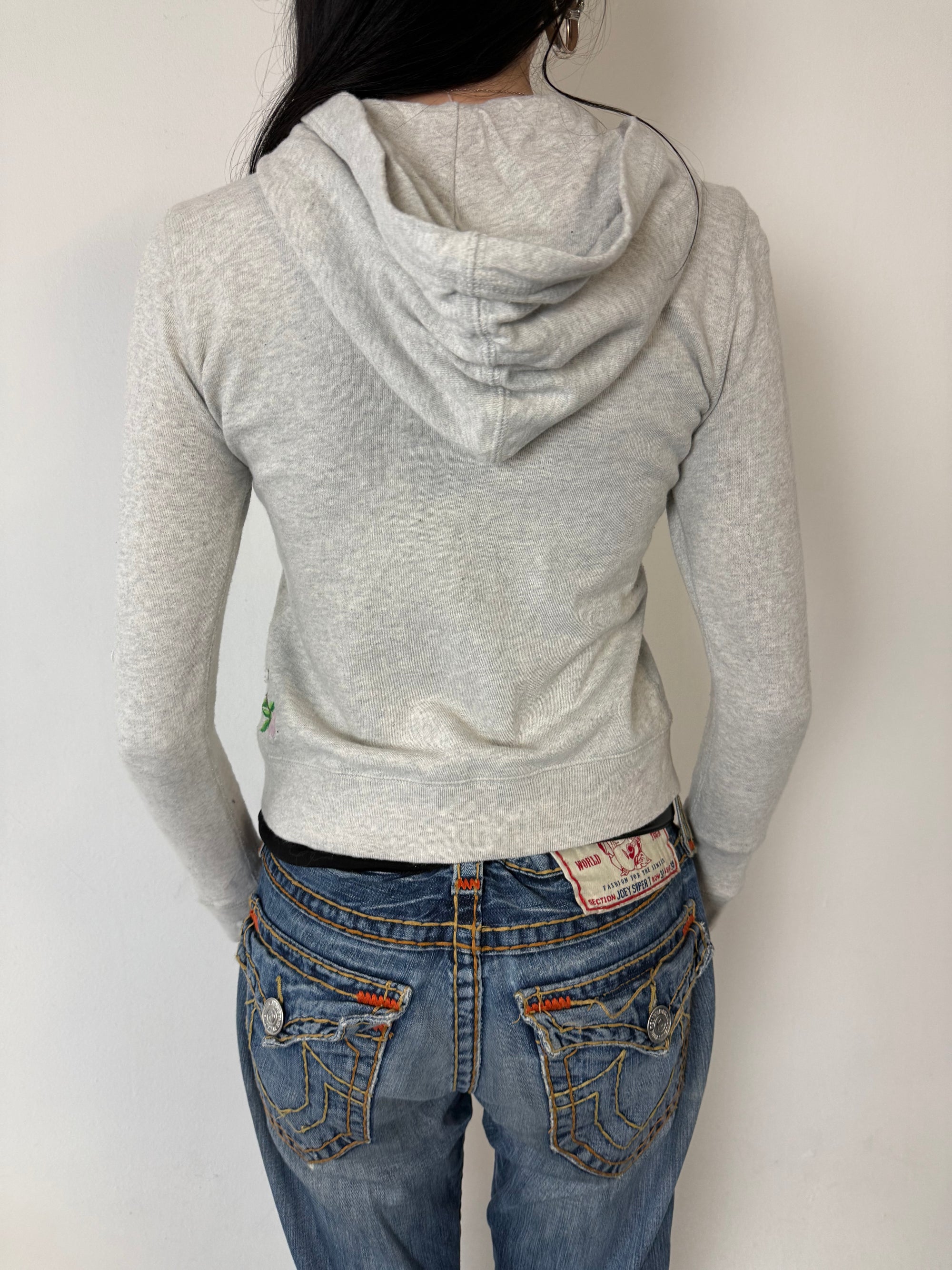 Ein grauer Zip Up Hoodie von Polo Ralph Lauren mit rosa Polo Aufdruck auf der Brust und kleinen patches überall verteilt in XS