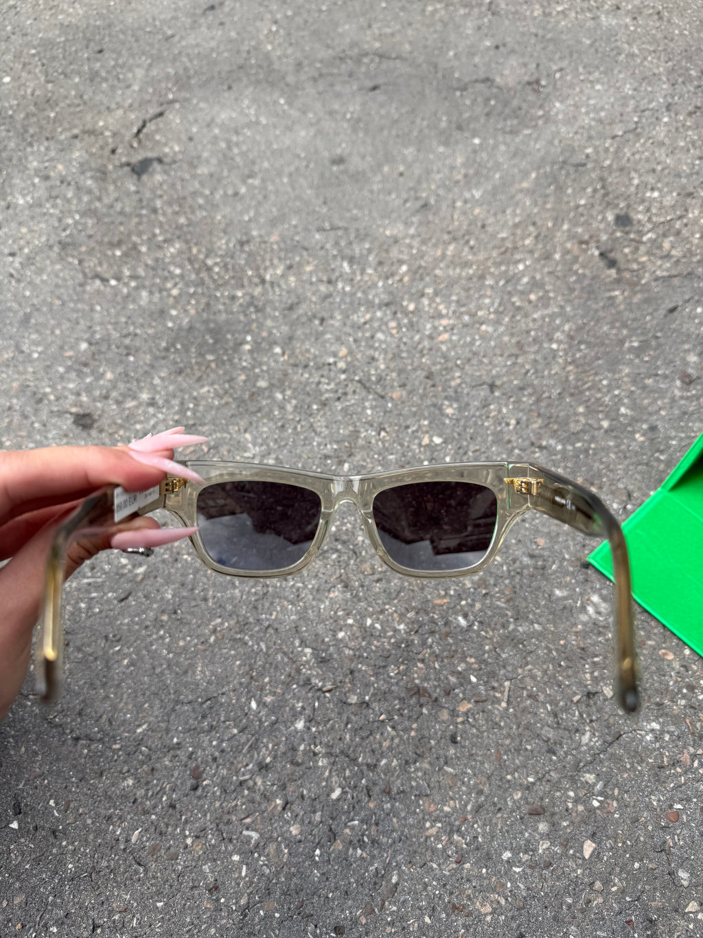 Eine beige transparente Sonnenbrille von Bottega Veneta mit Gold Details