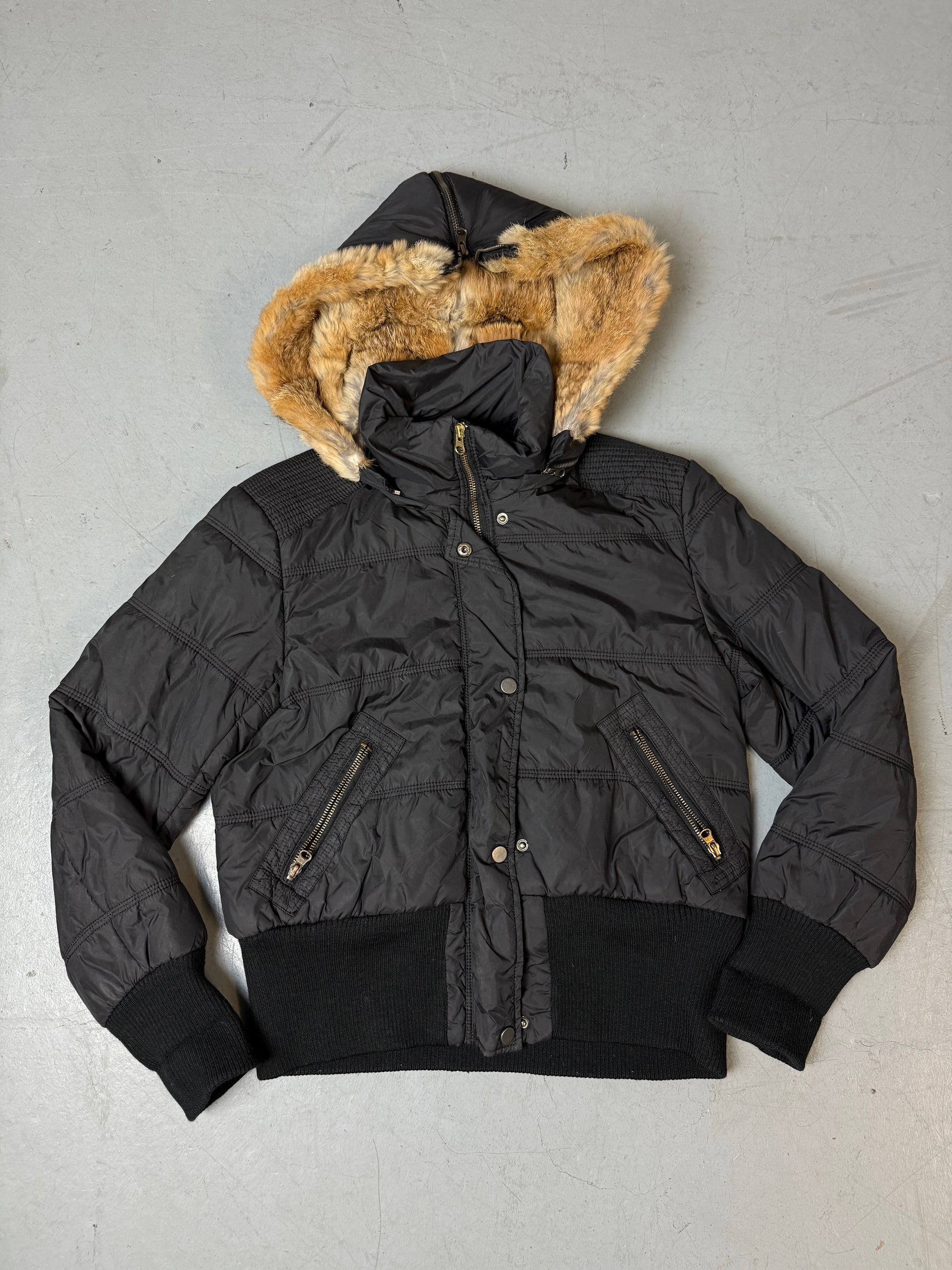 Eine schwarze cropped Puffer Jacke im Y2K Stil mit faux fur Kaputze 