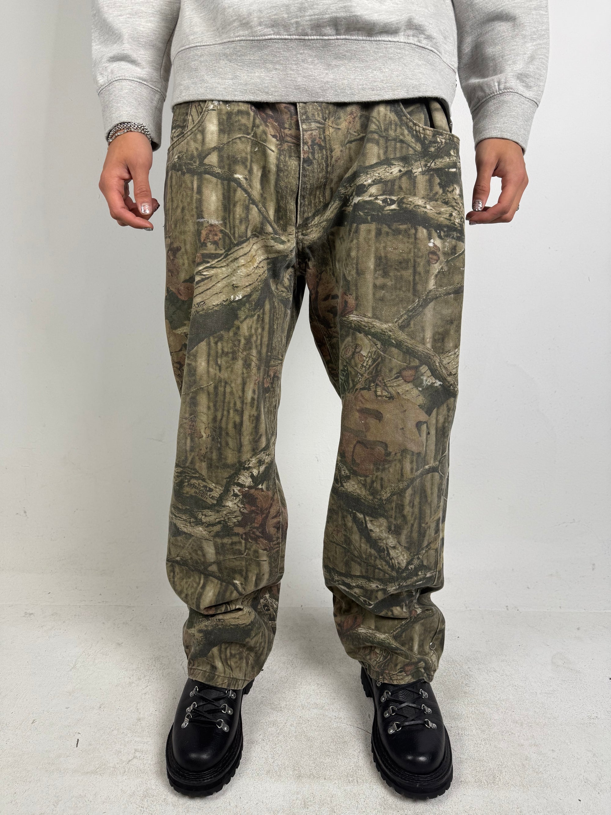 Eine baggy Hose von mossy oak in real tree camouflage Optik 