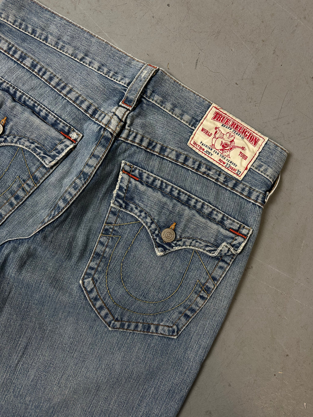 Eine blau-graue baggy True Religion Jeans mit weißen Hufeisen Stitching