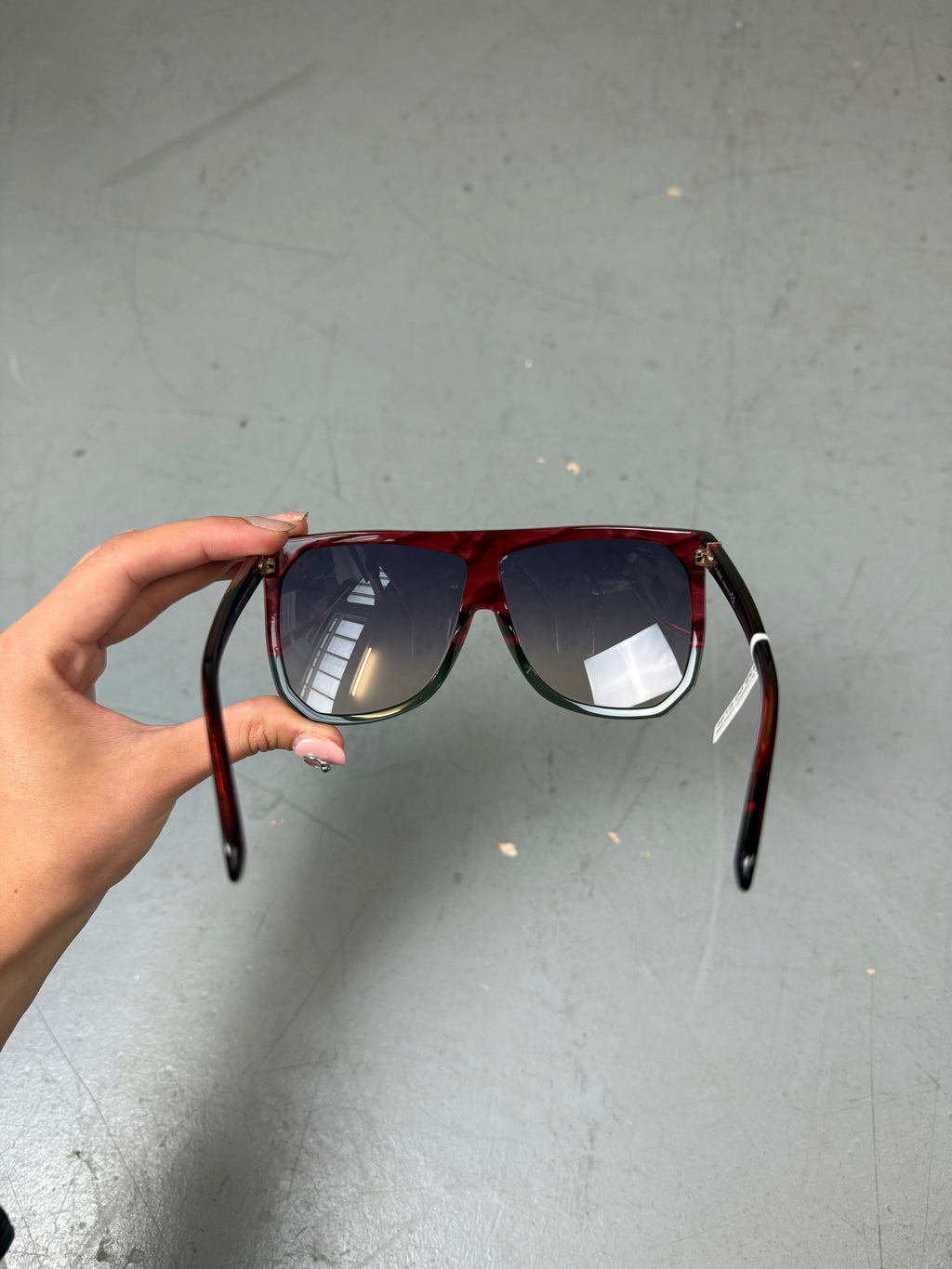 Eine Loewe Sonnenbrille mit großen dunklen Gläsern und rotem Gestell 