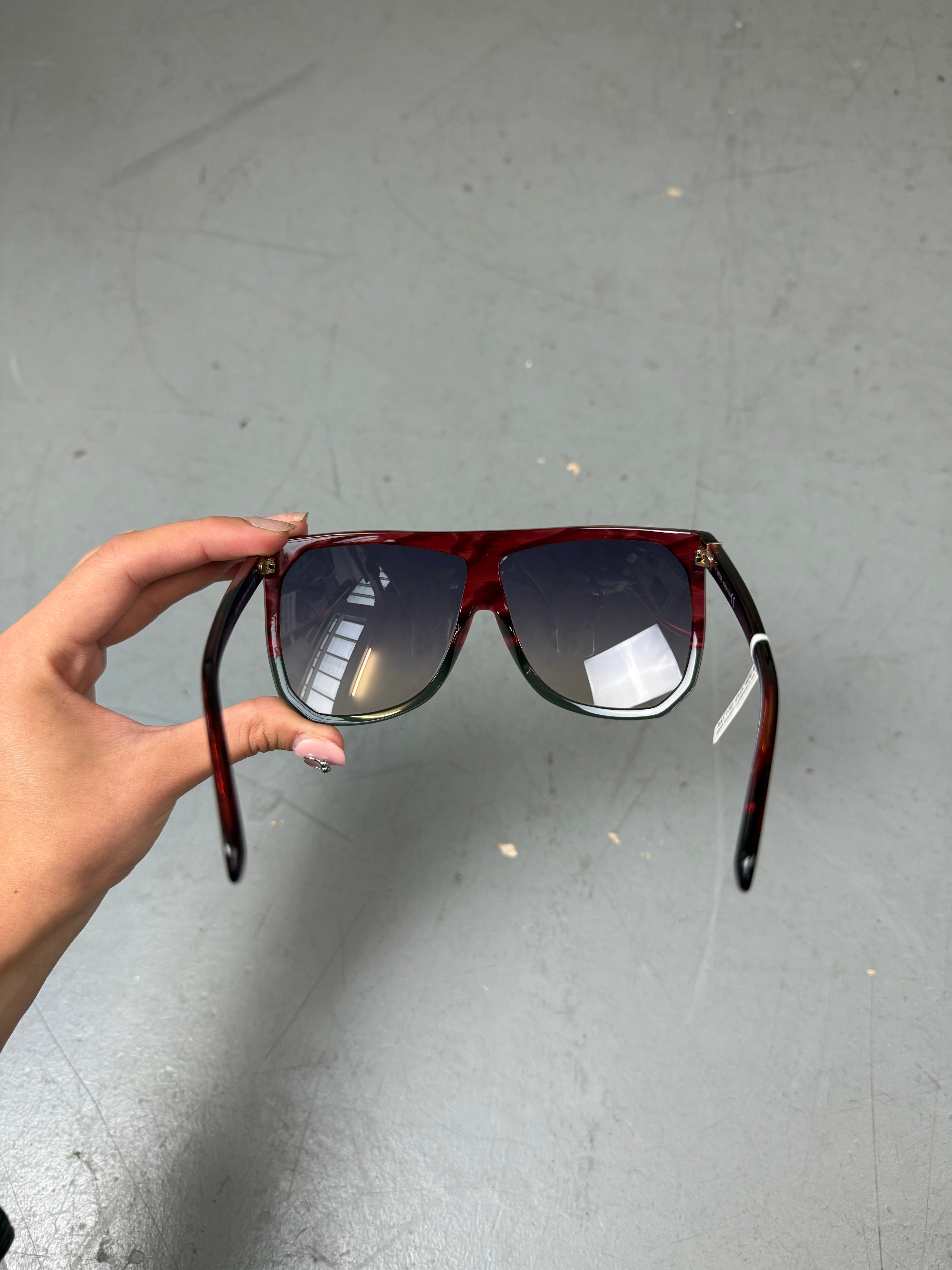 Eine Loewe Sonnenbrille mit großen dunklen Gläsern und rotem Gestell 