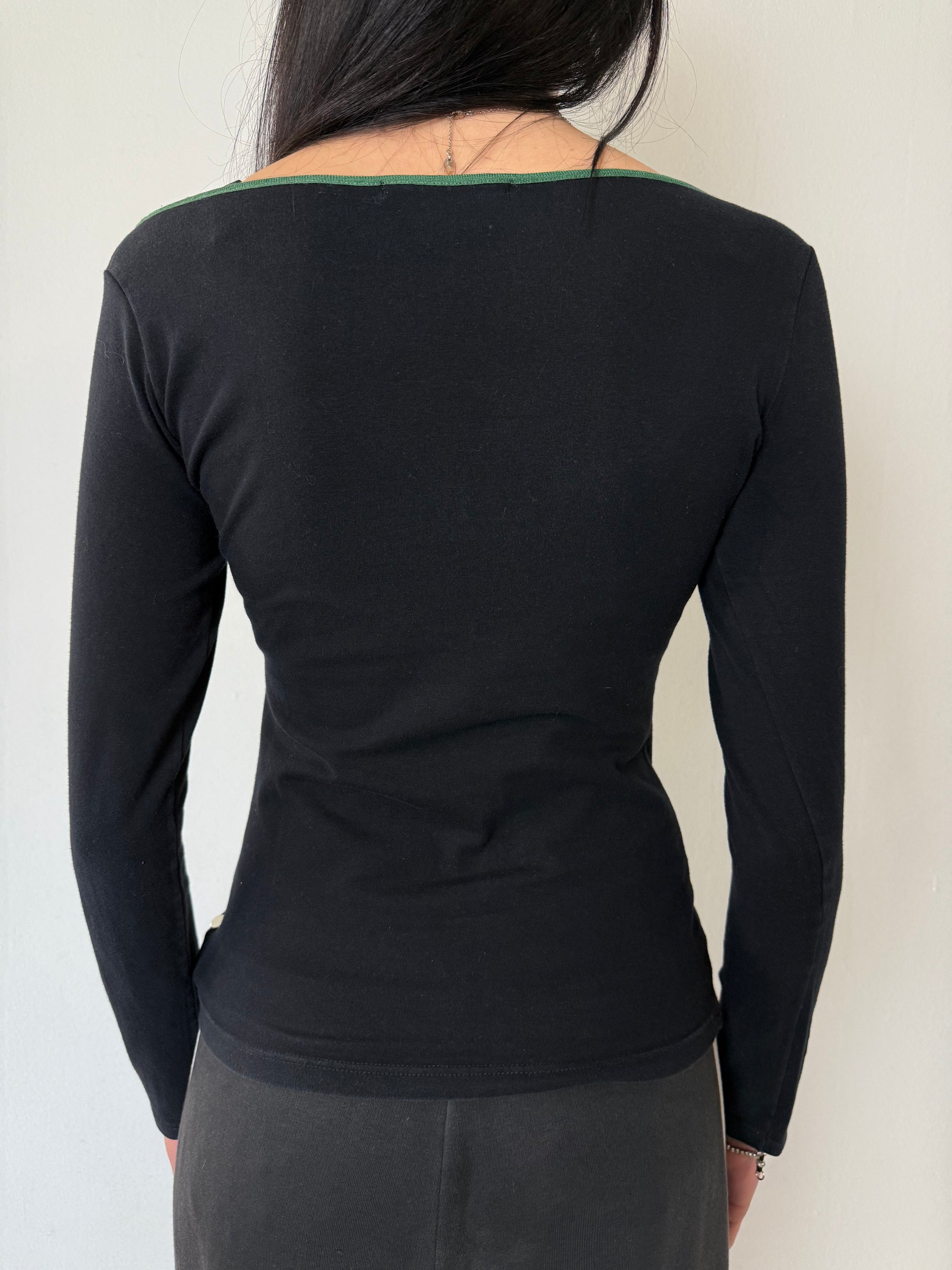 Ein schwarzes longsleeve mit einem grünen Joe Matta Aufschrift auf der Brust