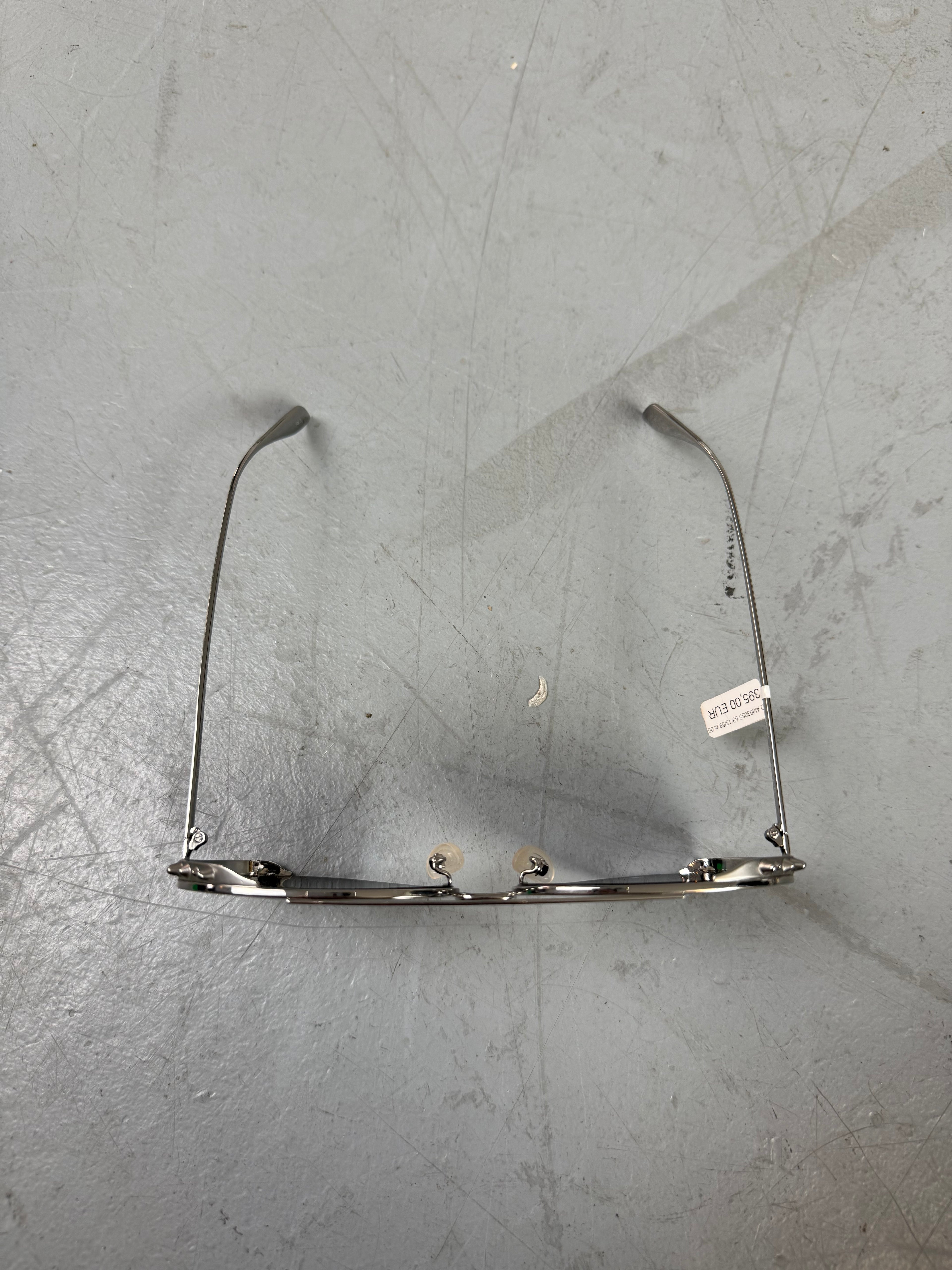 Eine Sonnenbrille von Alexander McQueen mit silbernen Nieten um die großen Gläser und dünnem Gestell 