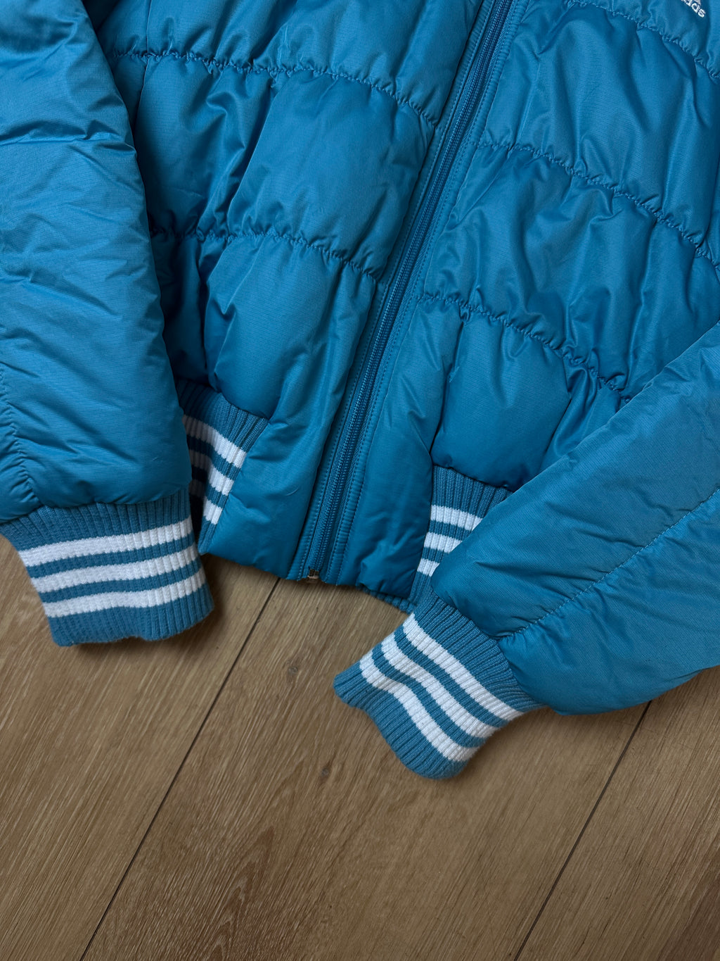 Detailbild  einer Vintage Blue Adidas Puffer Jacket von Ärmel und Bund 