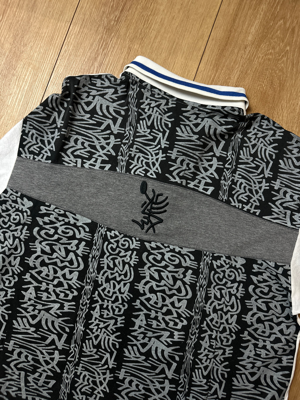 Ein Polo Shirt von Lotto in weiß mit blau schwarzen Ärmeln vintage Y2K 