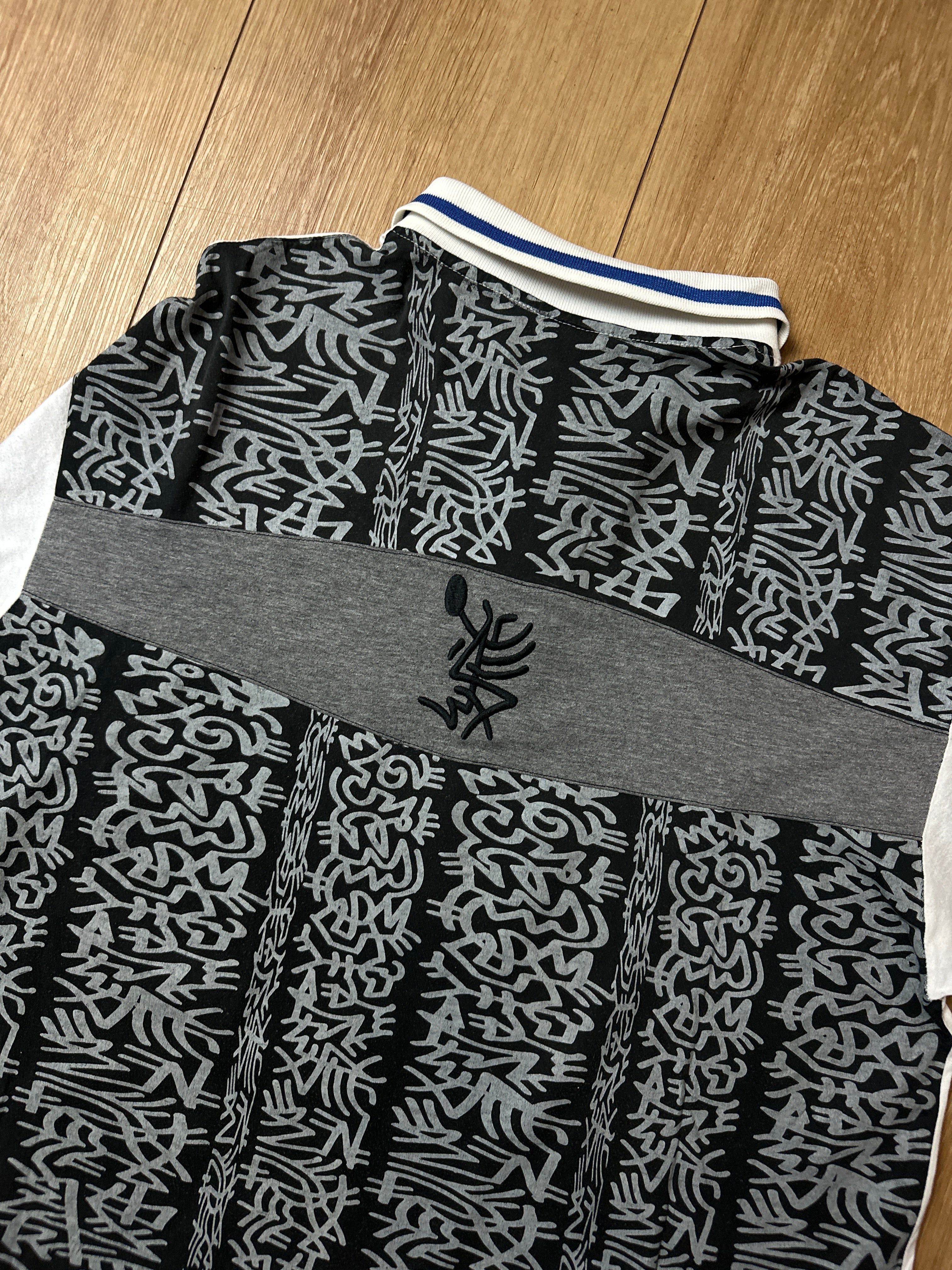 Ein Polo Shirt von Lotto in weiß mit blau schwarzen Ärmeln vintage Y2K 