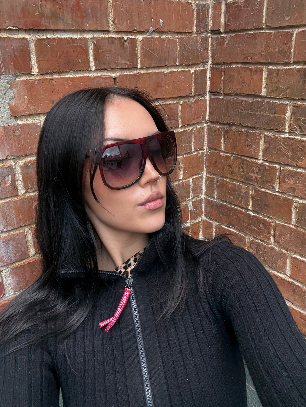 Eine Loewe Sonnenbrille mit großen dunklen Gläsern und rotem Gestell 