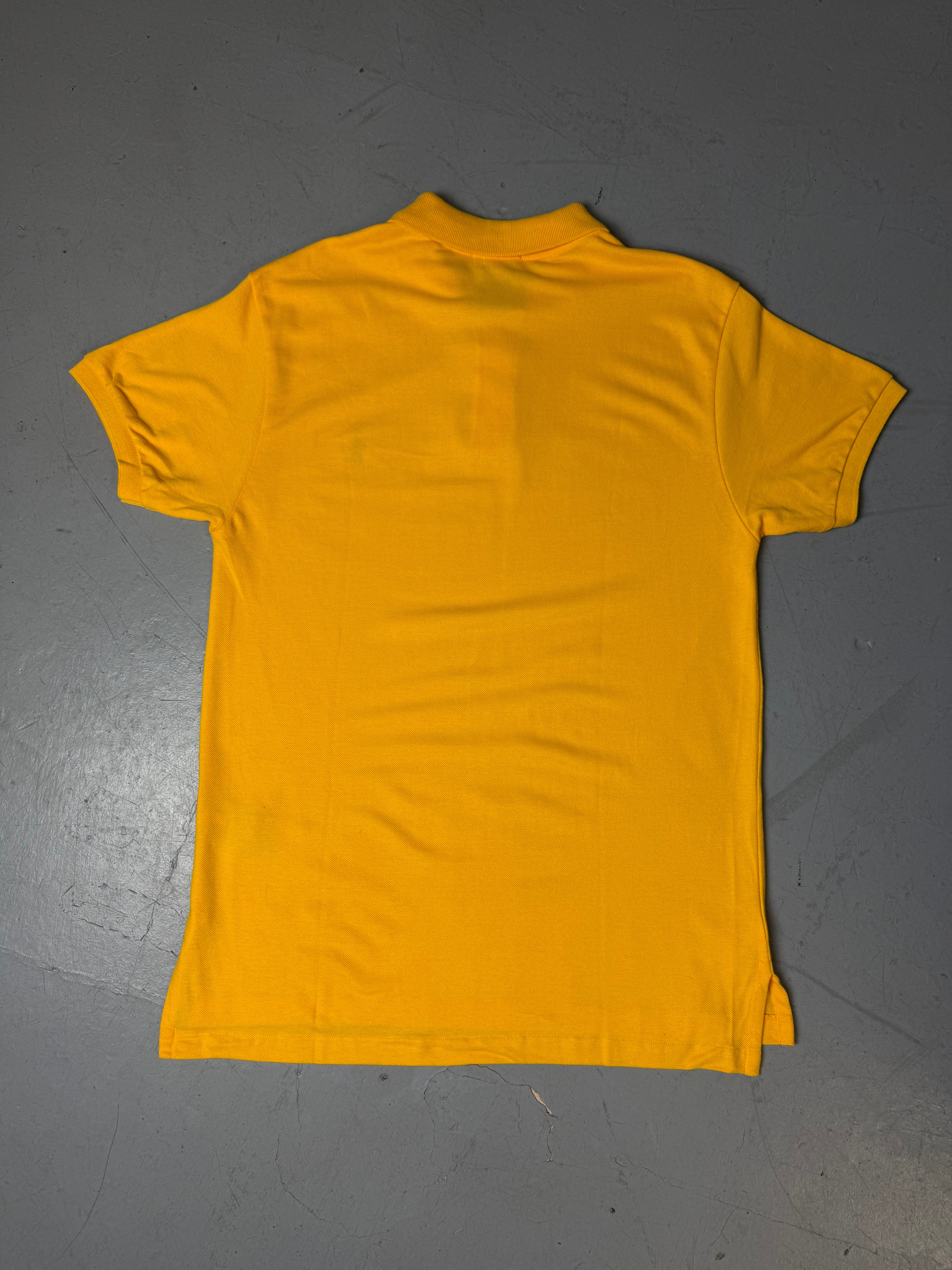 Ein gelbes Polo von Ralph Lauren mit blauem Reiter auf der Brust in L