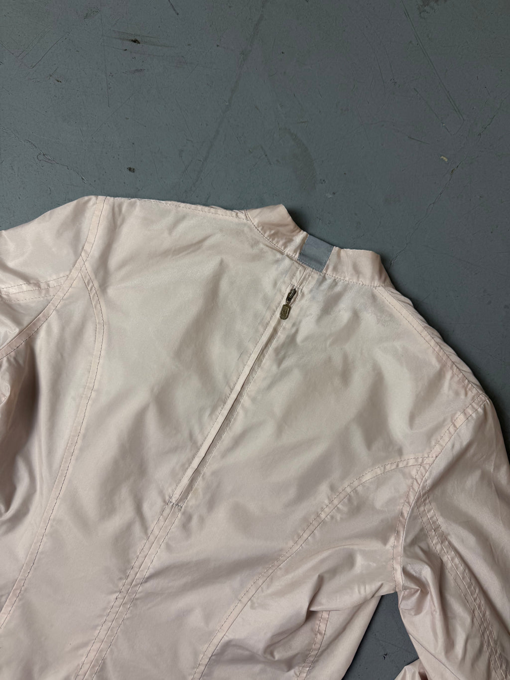 Vintage Belstaff Light Pink Jacket Getragen mit schrägem zipper vor weißer Wand