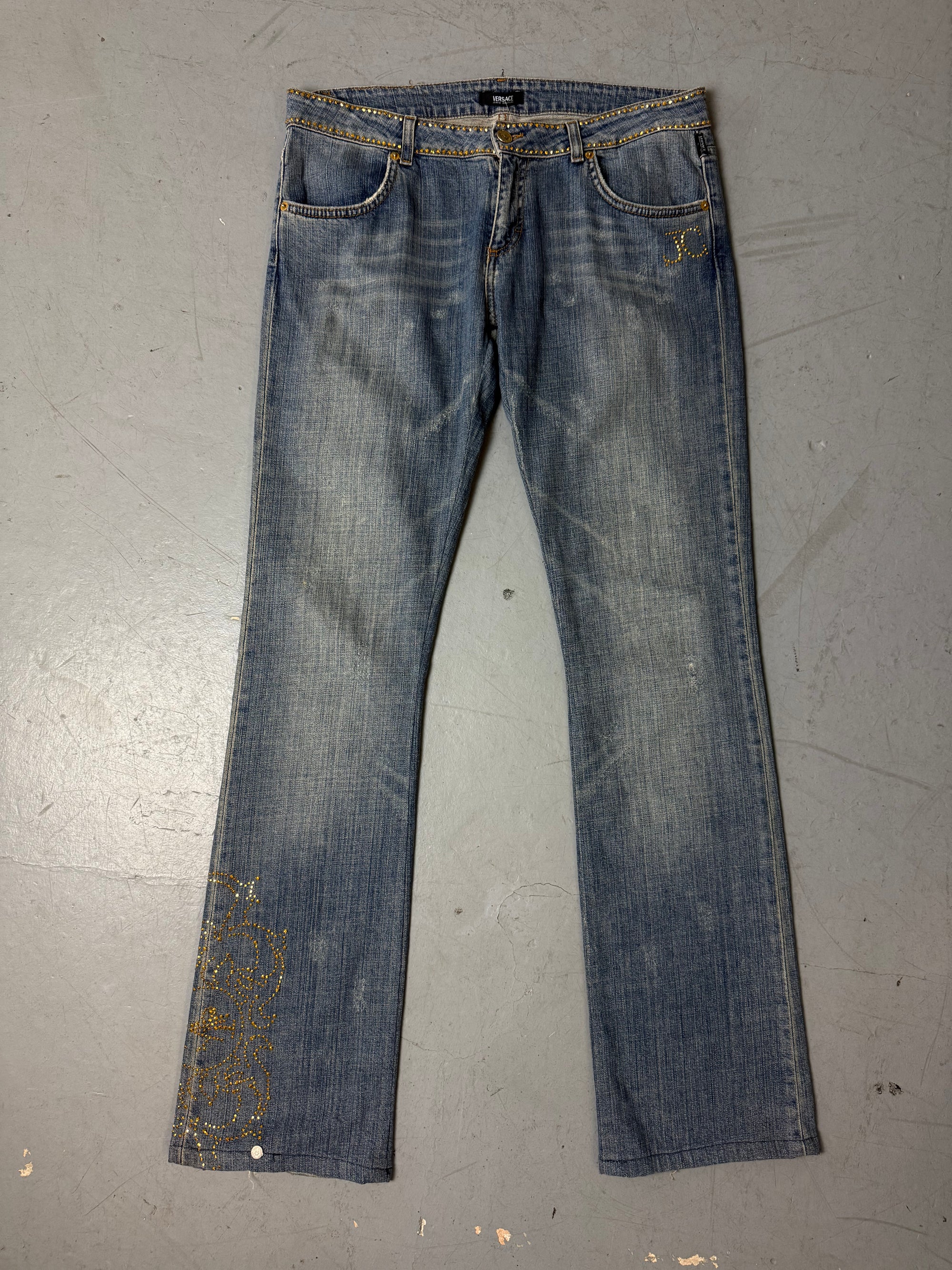 Eine low waist blue washed Versace Jeans im Bootcut Schnitt mit goldenen rhinestones um den Bund und am Bein 