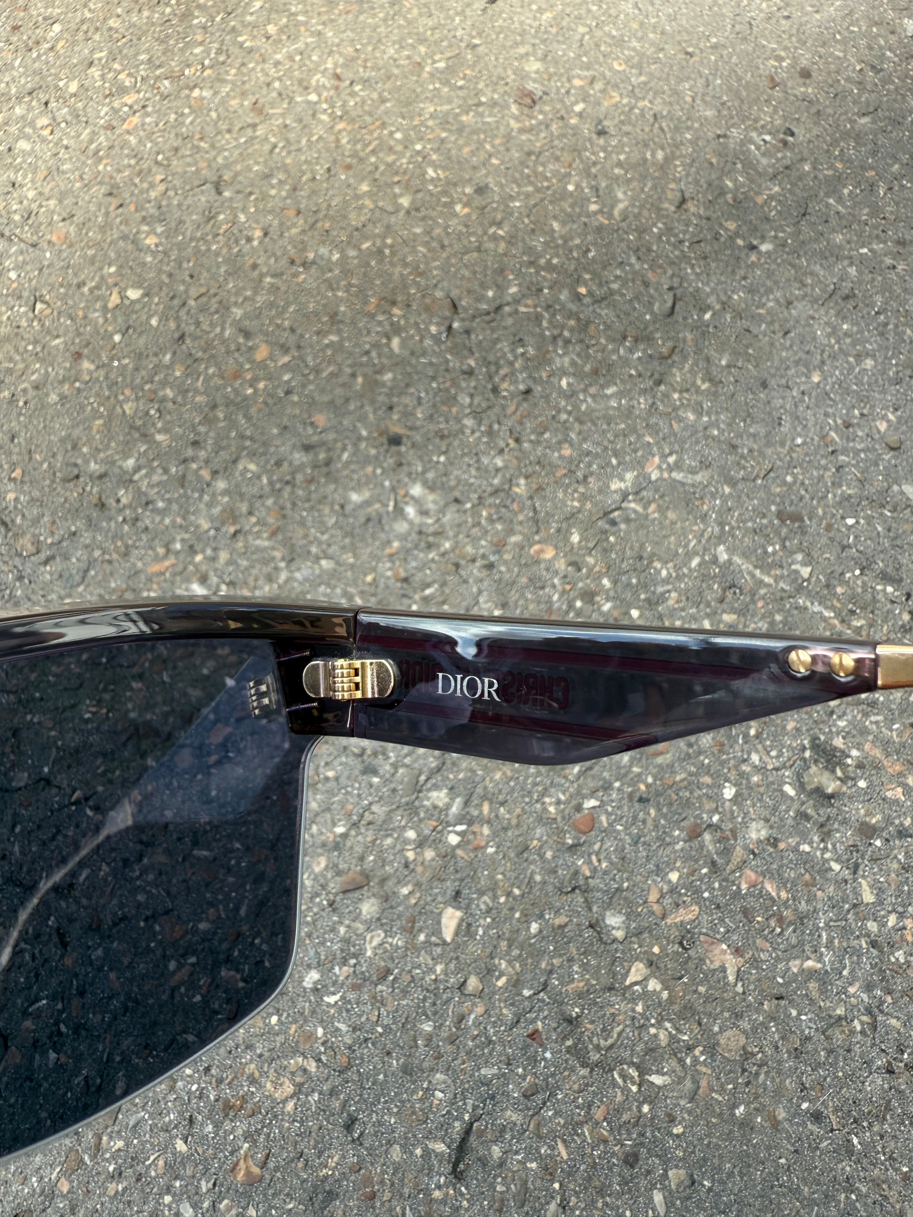 Eine schwarze Sonnenbrille von Dior mit dem Monogram auf den Gläsern und dem Markennamen auf den Bügeln