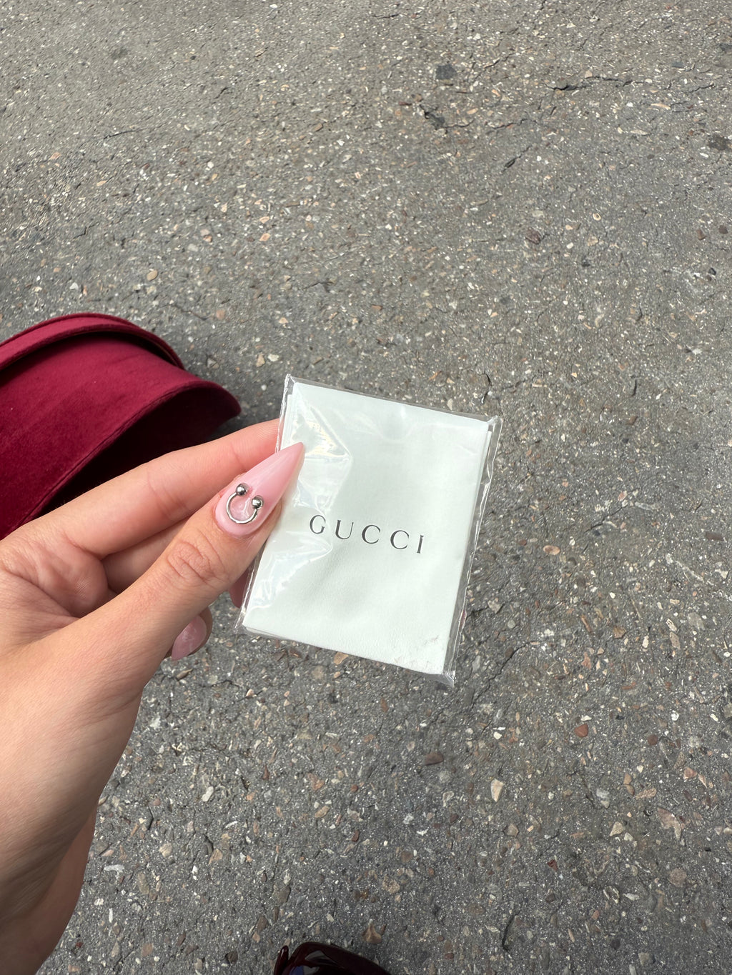 Eine burgunderrote Sonnenbrille von Gucci mit dem Logo in Gold an der Seite und großen quadratischen Gläsern