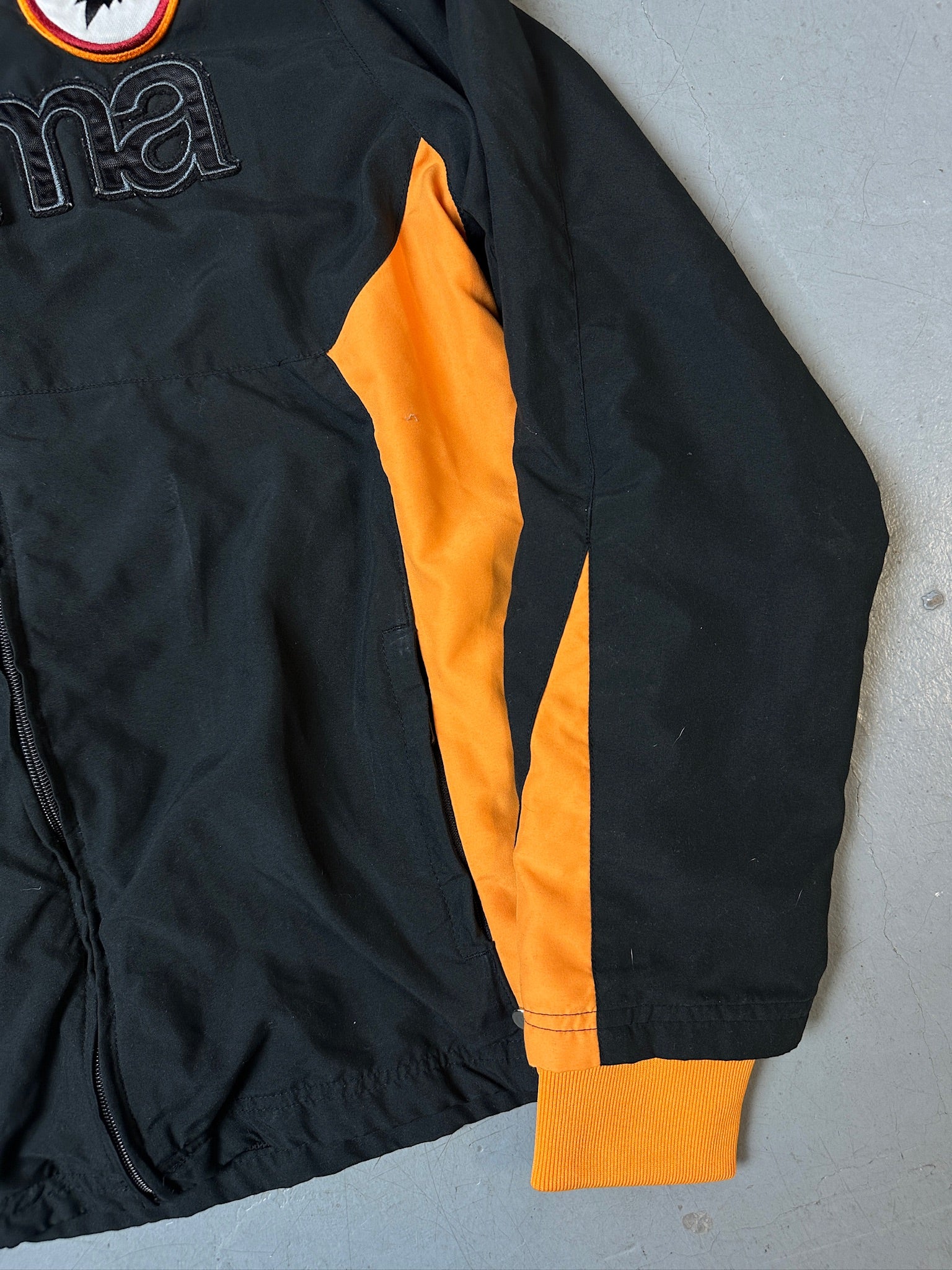 Eine schwarz orange Track Jacke von kappa von dem Fußballverein as roma 