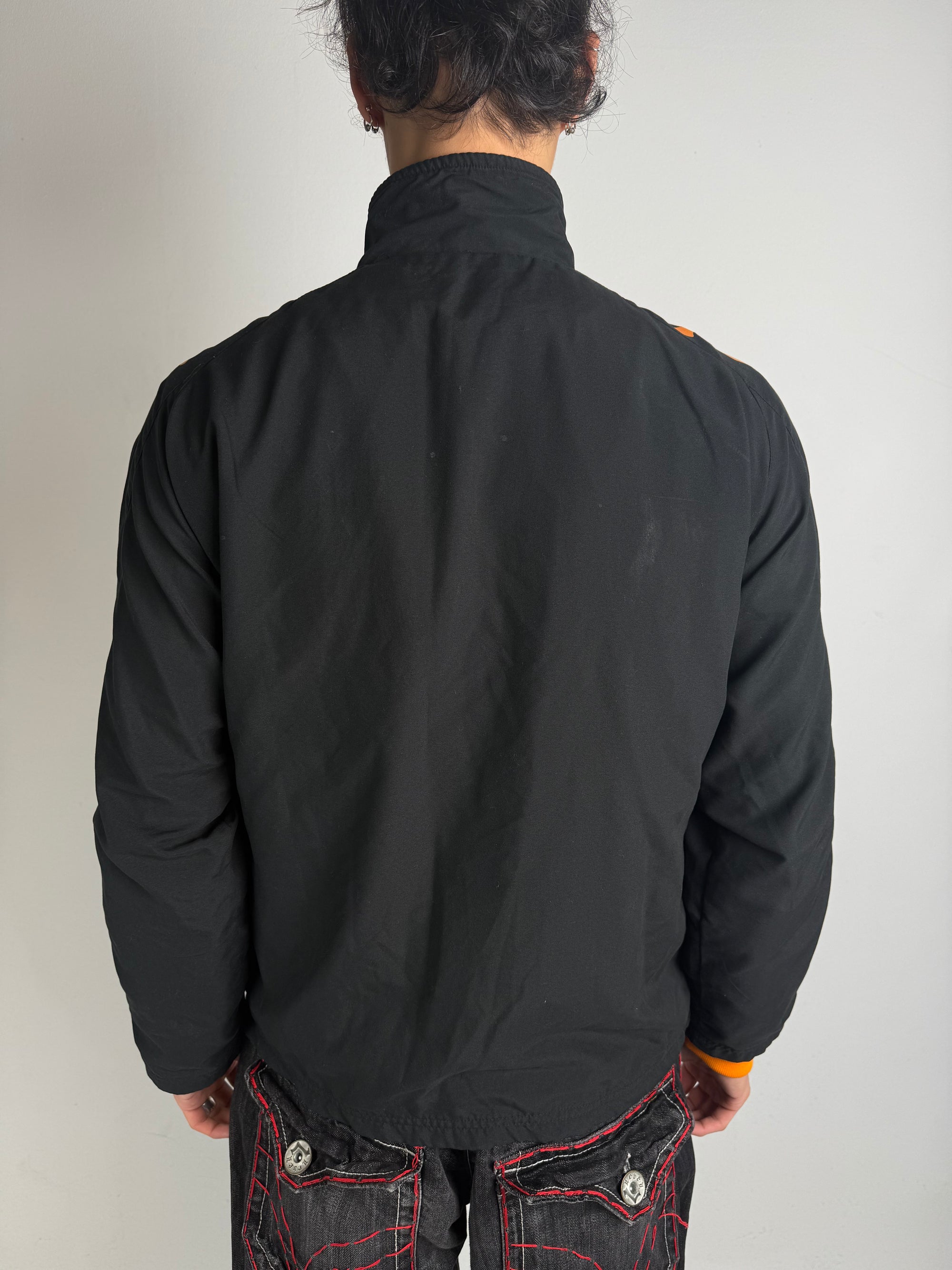 Eine schwarz orange Track Jacke von kappa von dem Fußballverein as roma 