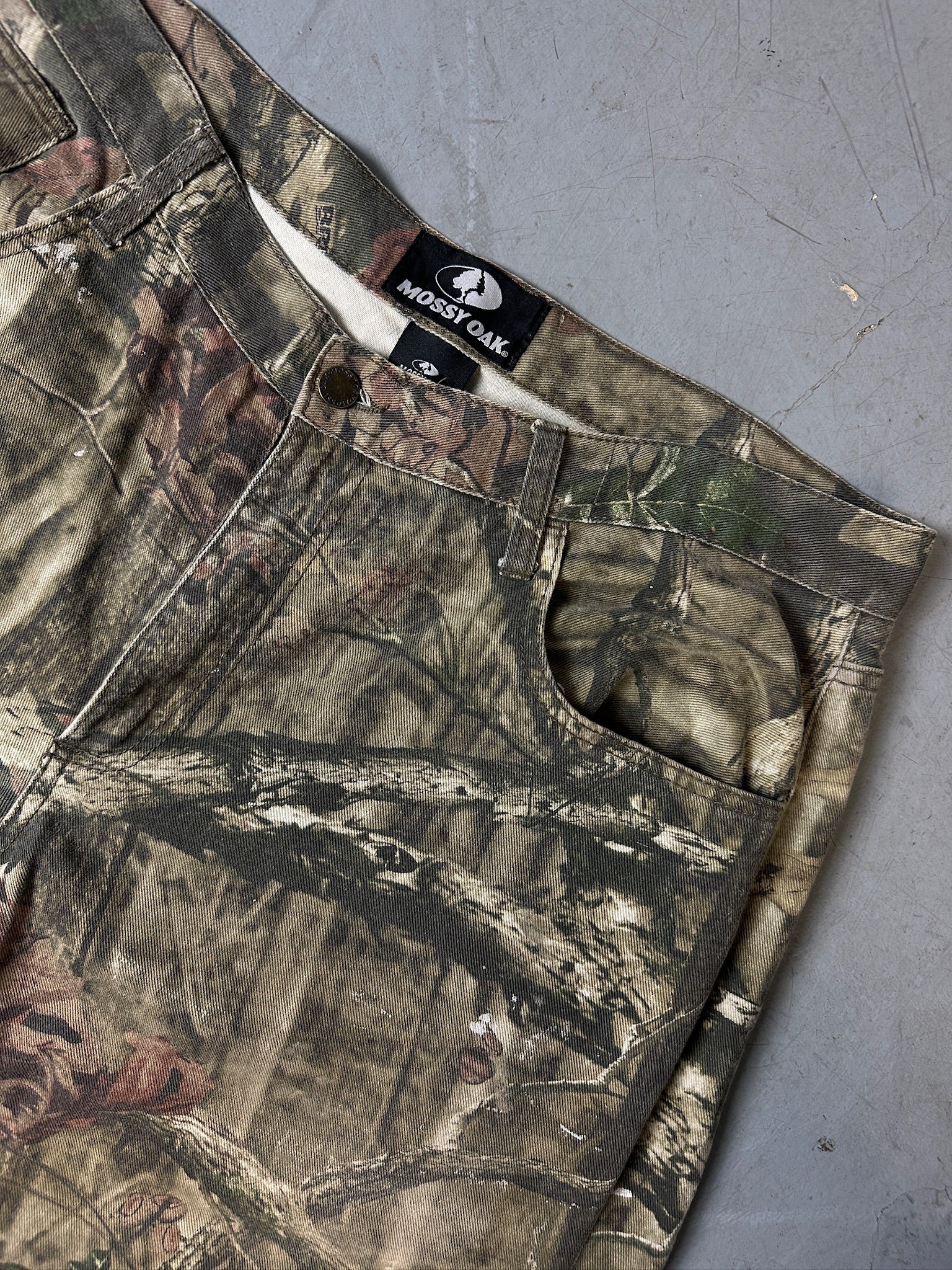 Eine baggy Hose von mossy oak in real tree camouflage Optik 