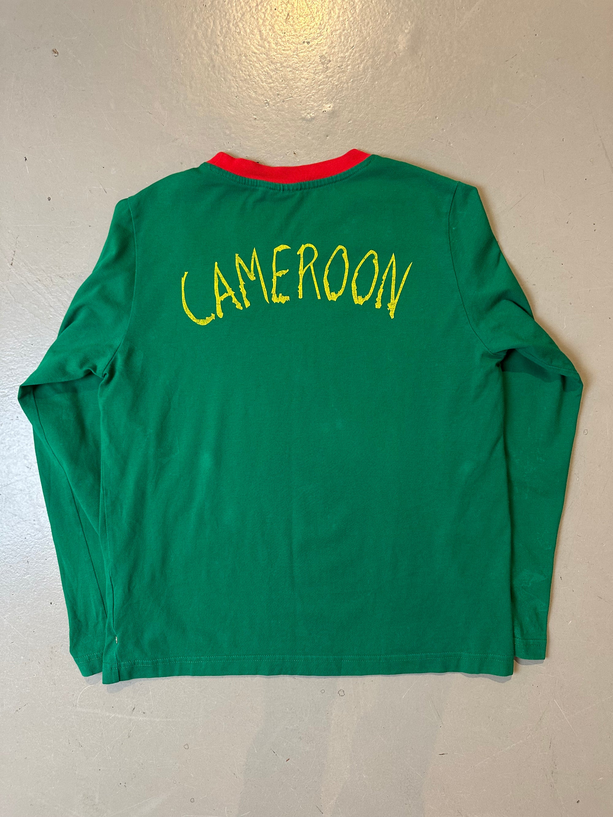 Ein grünes Longsleeve von Pomo mit roten Details an Ärmel und Kragen und der Aufschrift Cameroon auf dem Rücken in L