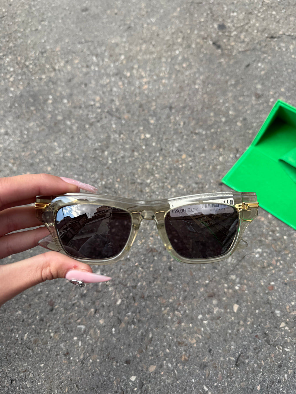 Eine beige transparente Sonnenbrille von Bottega Veneta mit Gold Details