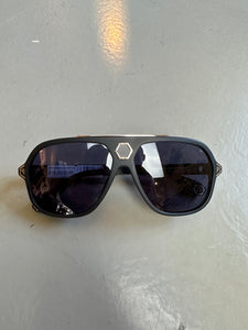 Zu sehen ist ein Produktbild von einer Philipp Plein Sunglasses von vorne vor einem grauen Hintergrund.