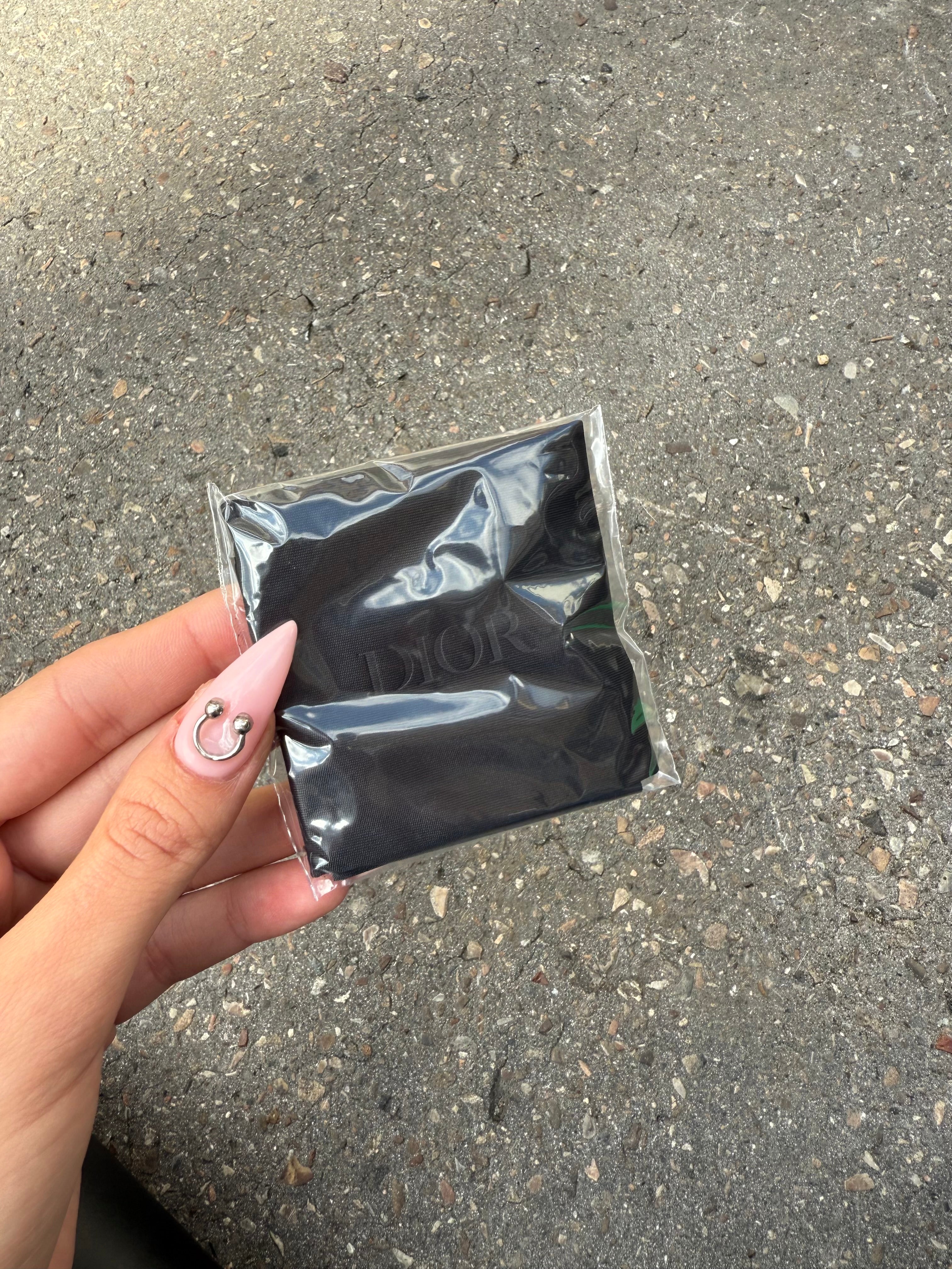 Eine schwarze Sonnenbrille von Dior mit dem Monogram auf den Gläsern und dem Markennamen auf den Bügeln